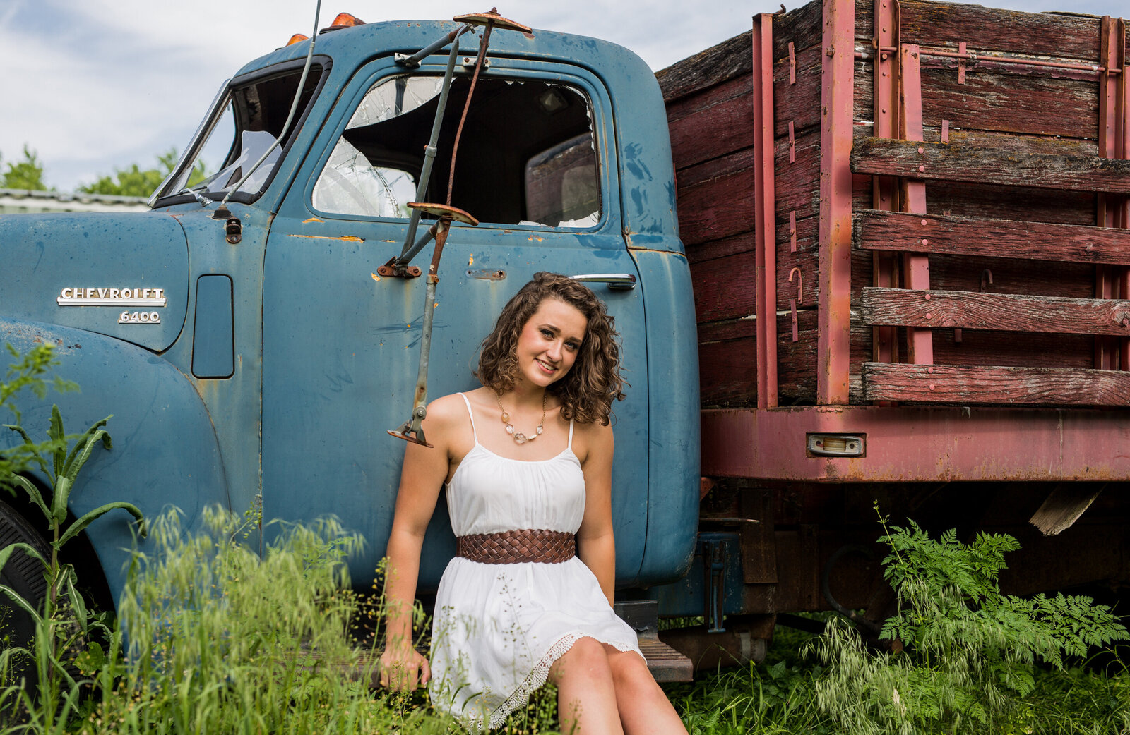 Payten poses by an old blue truck