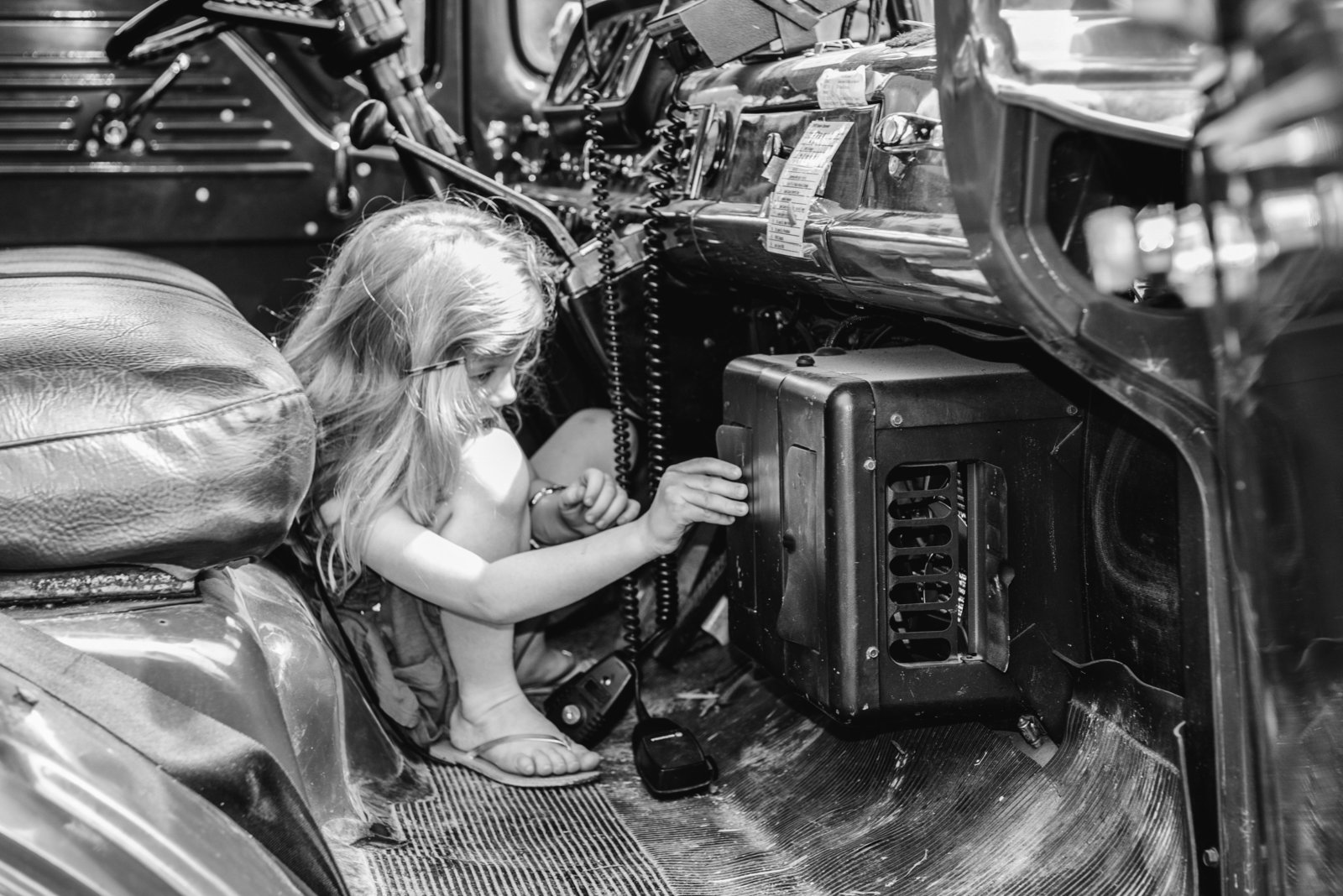 Little girl playing with radio in black and white