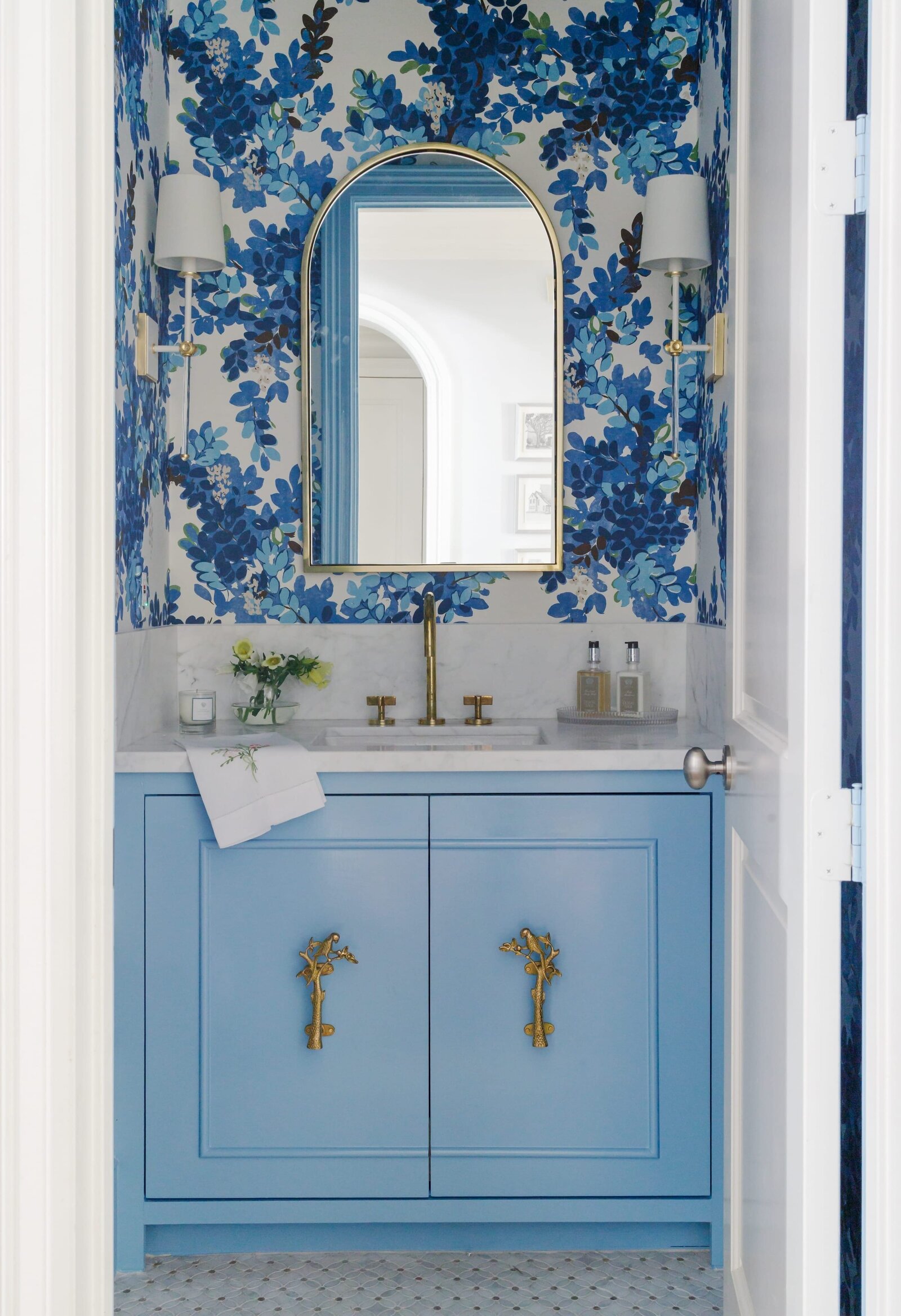 vision and hammer bathroom with blue floral wallpaper and arched mirror