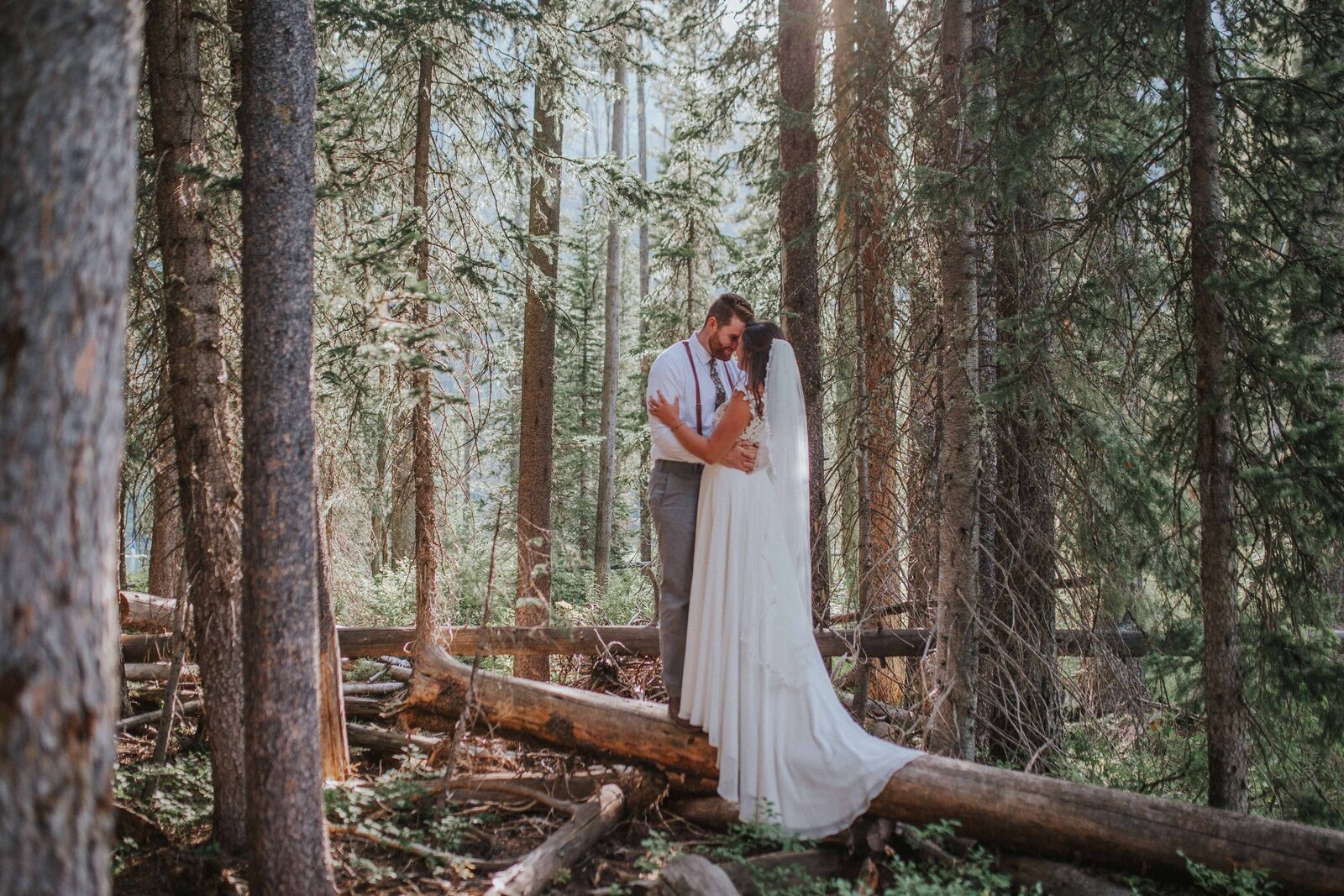Sacramento Wedding Photographer captures bride and groom standing on log together in forest bridals at Lake Tahoe elopement