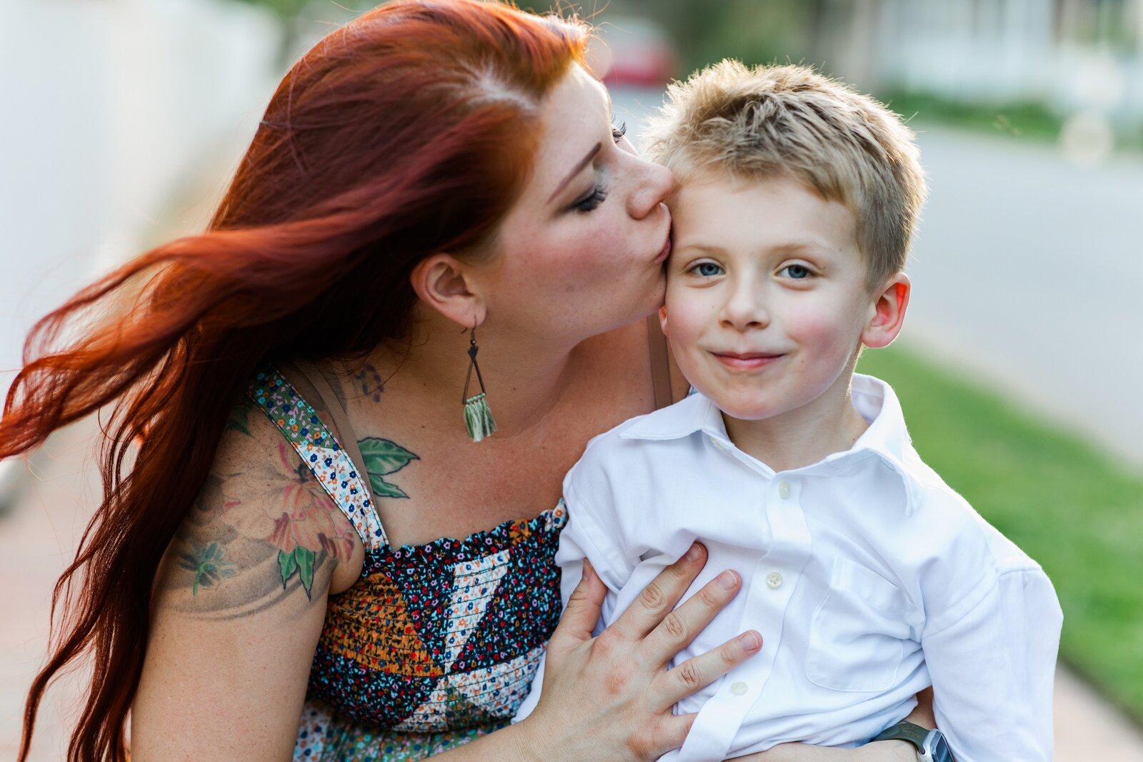 Downtown Pensacola Family Photography session with family of 4. Mom kissing son on the cheek.