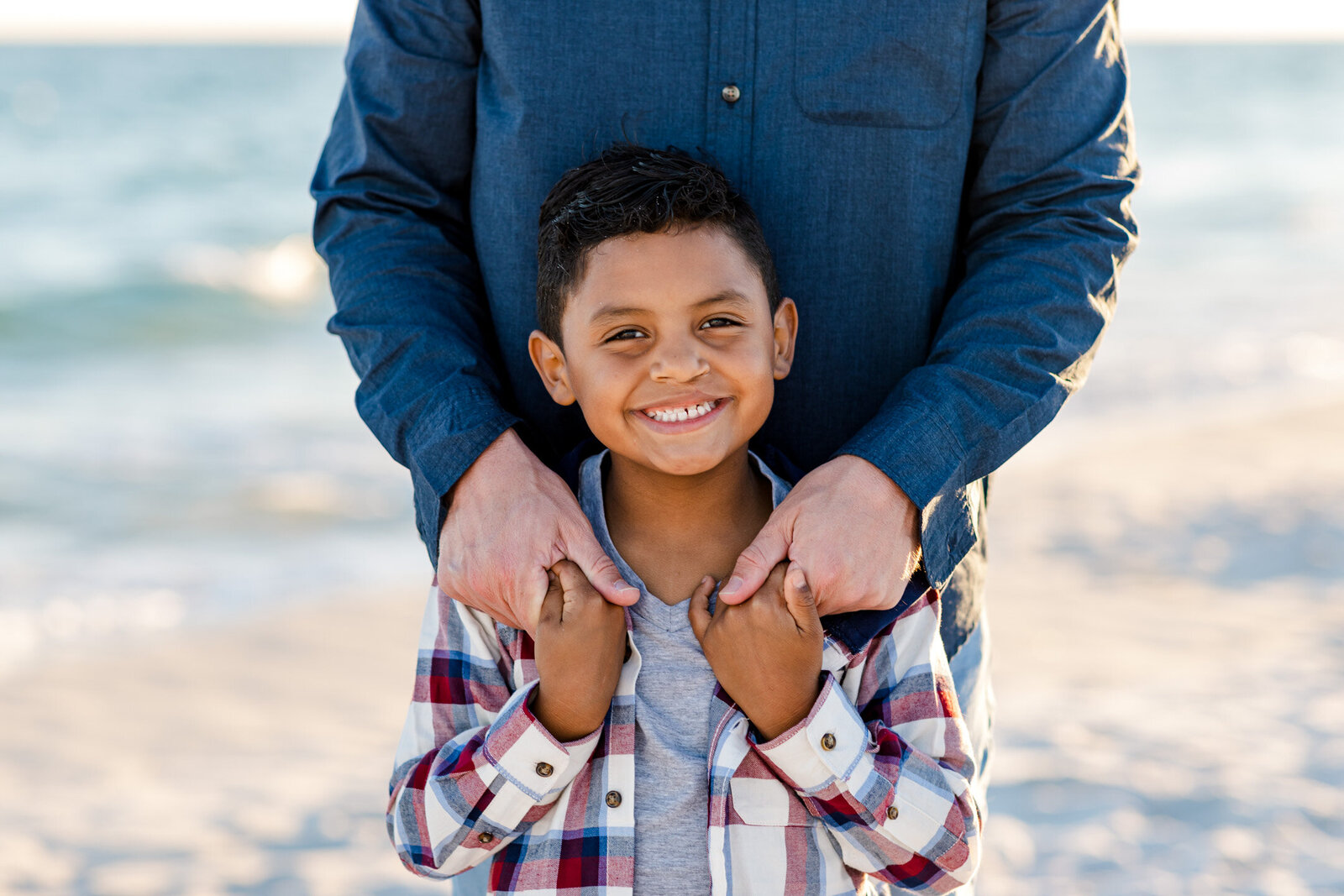 Father and son pose during family photo session at Pensacola Beach.