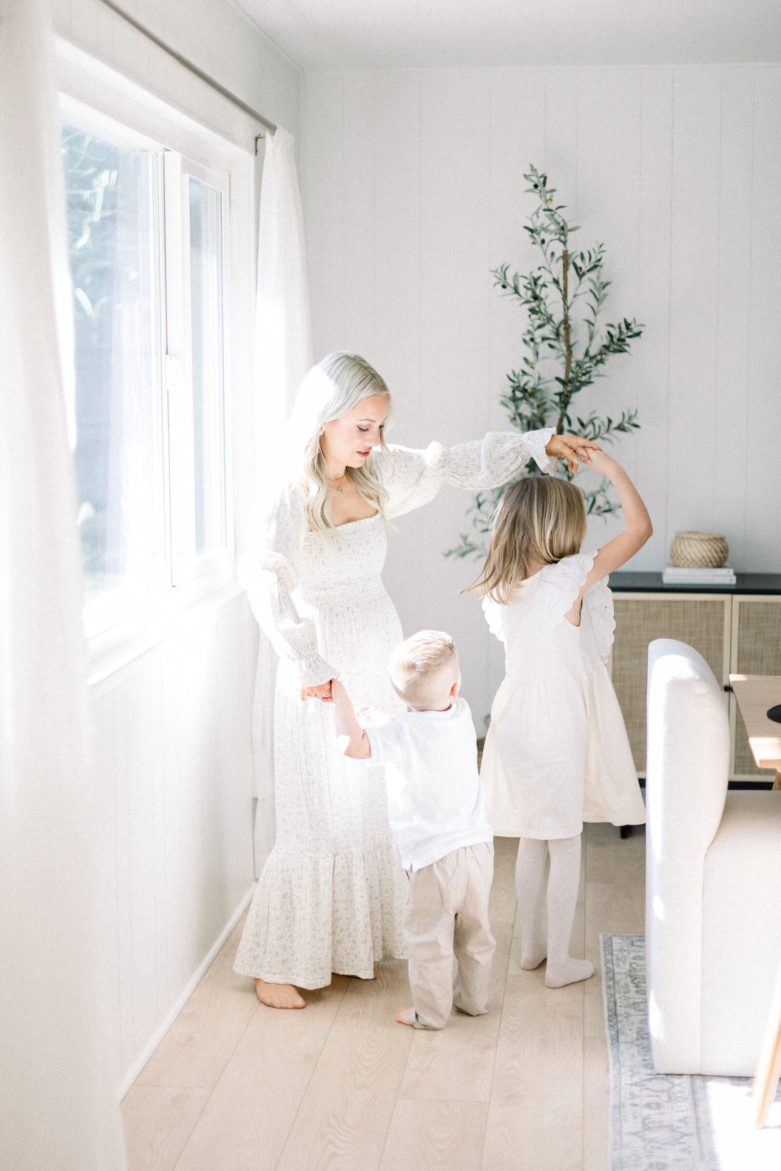 image of young mother dancing with her two children taken by Sacramento Newborn Photographer Kelsey Krall Photography