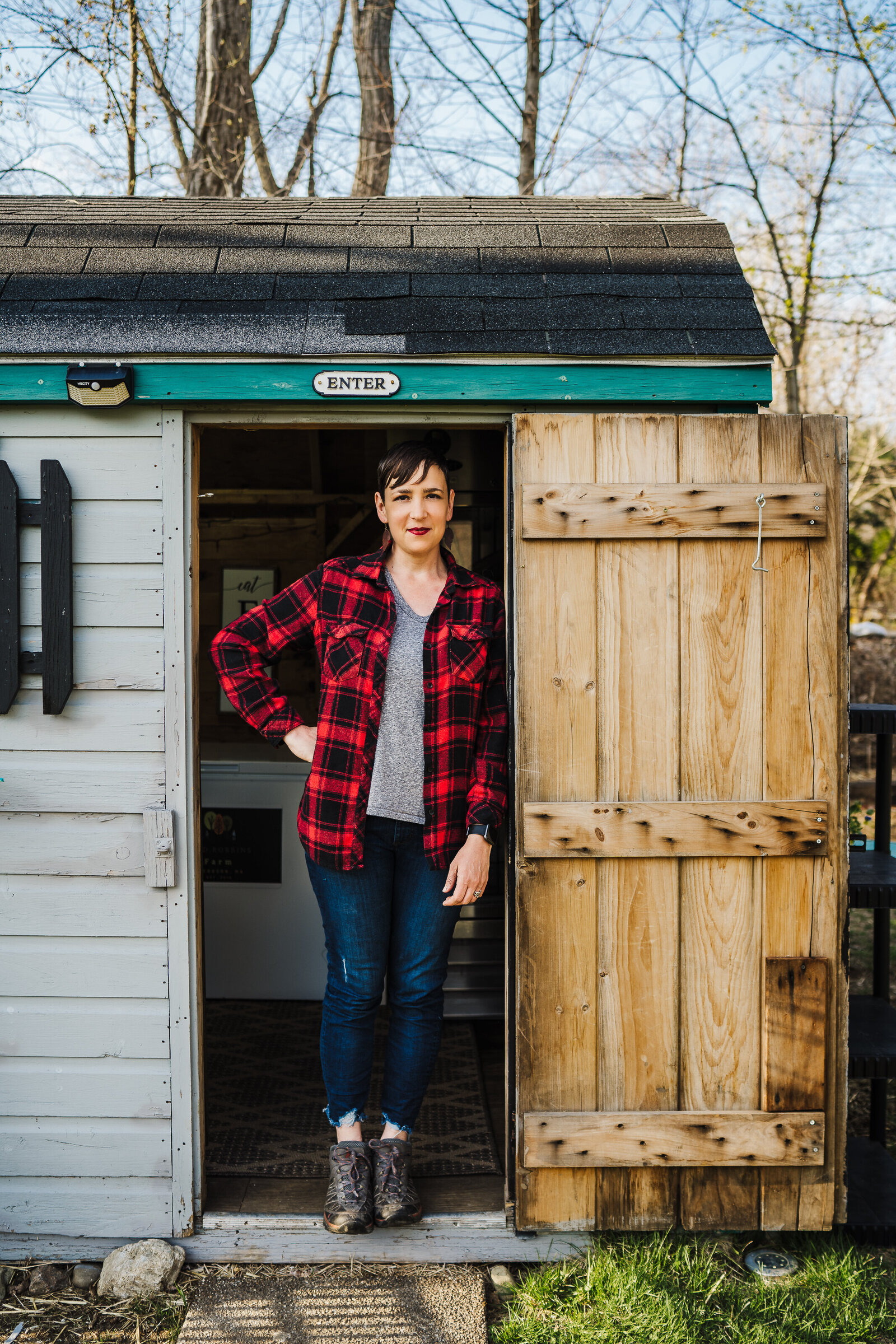farmer stands in doorway during brand photo session