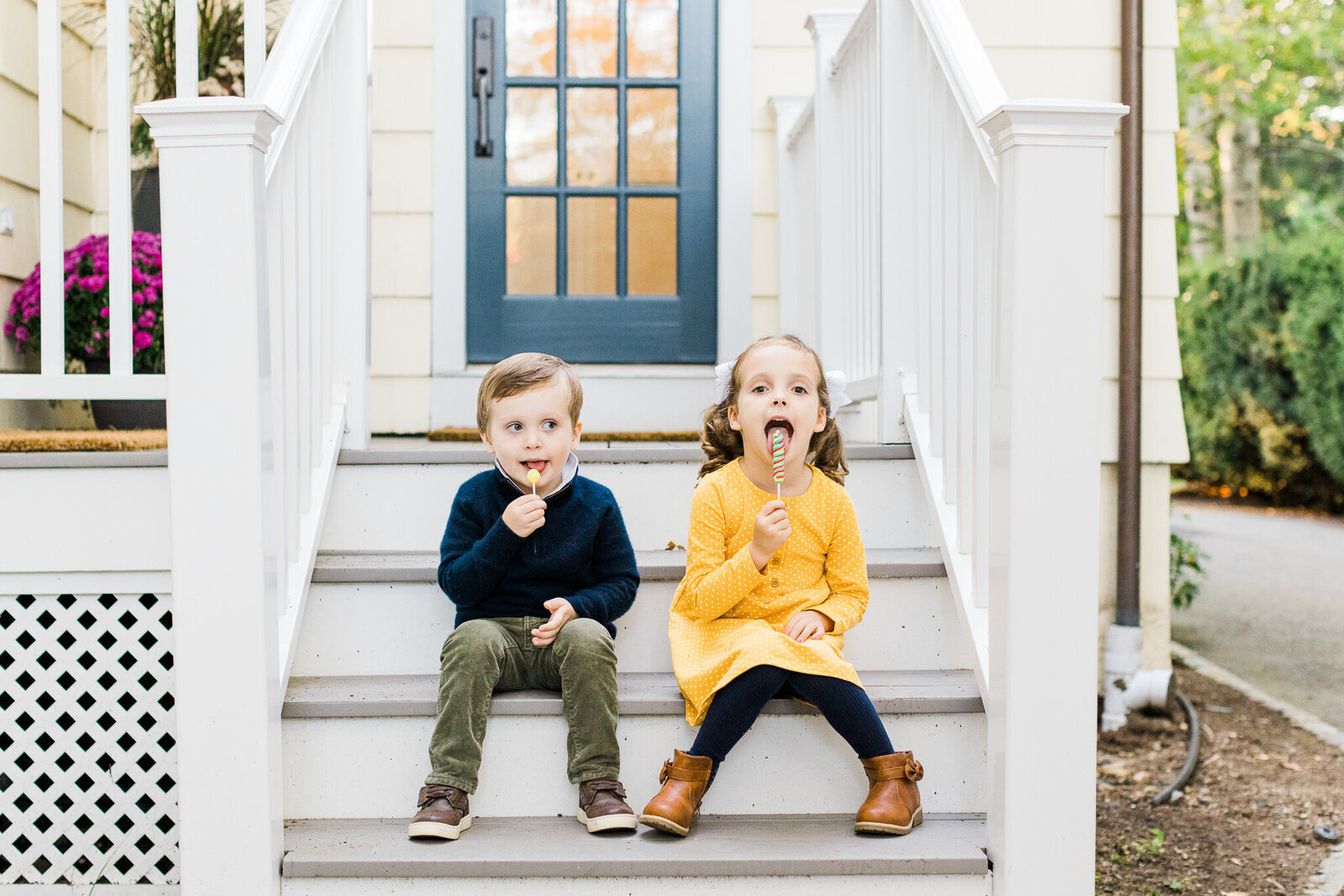 siblings with lollipops on steps