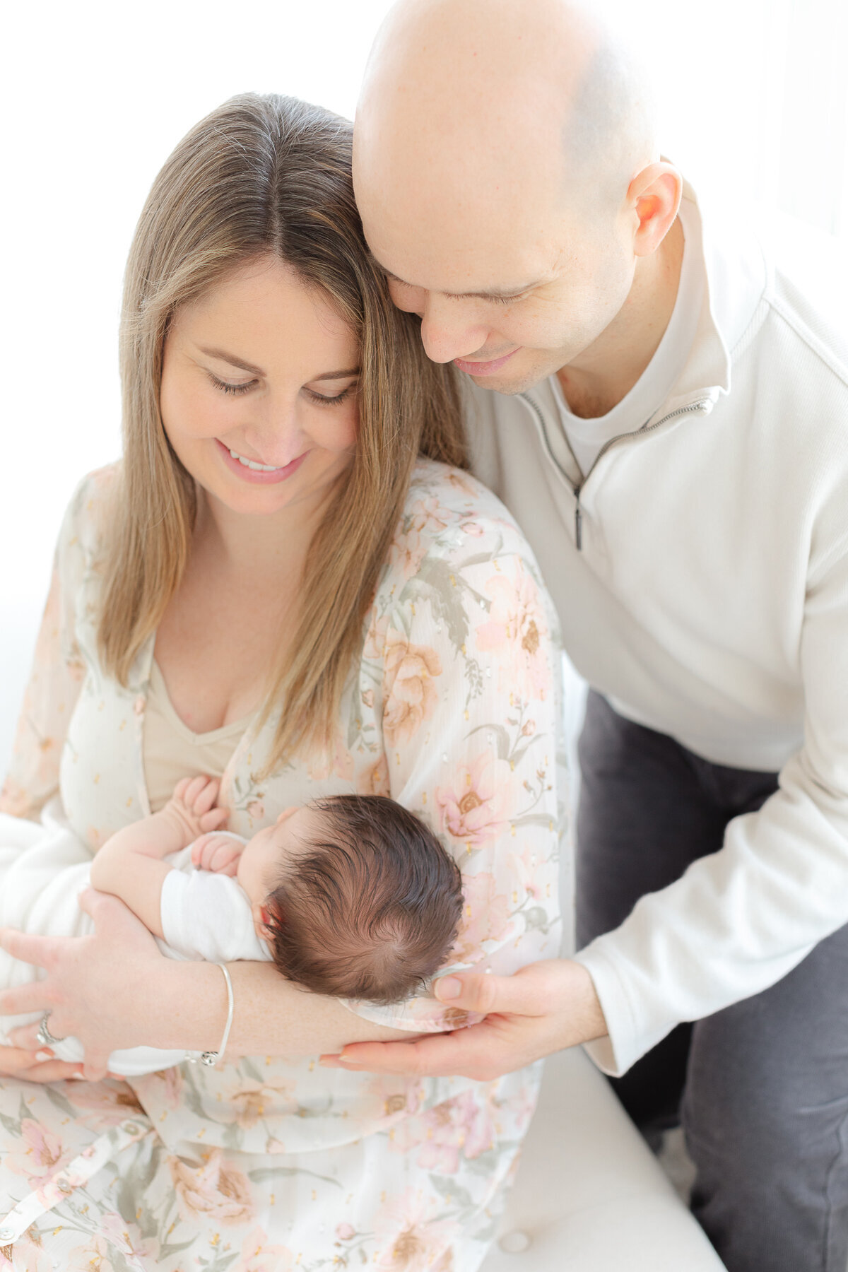 young couple holds newborn baby during massachusetts newborn photography photoshoot