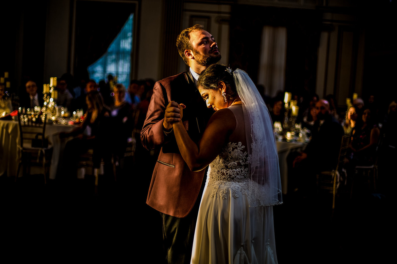 Bride and groom dance while framed in light of setting sun at the George Washington Hotel