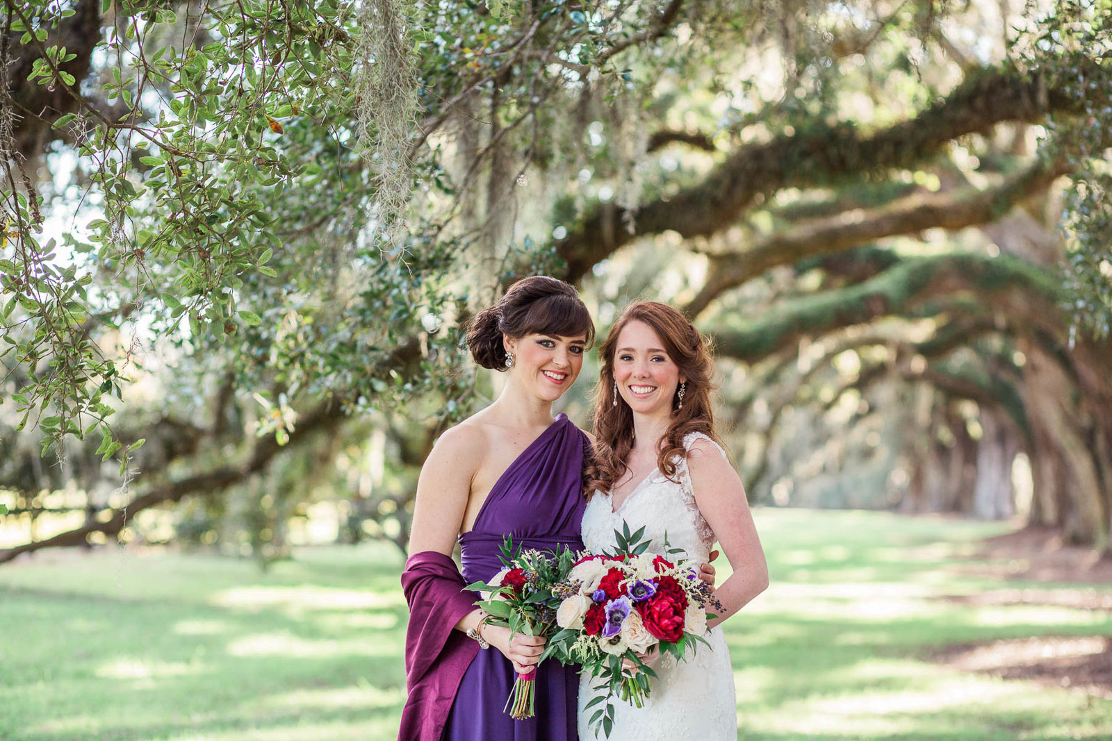 Bride and bridesmaids stand on avenue of oaks, Boone Hall Plantation, Charleston, South Carolina. Kate Timbers Photography.