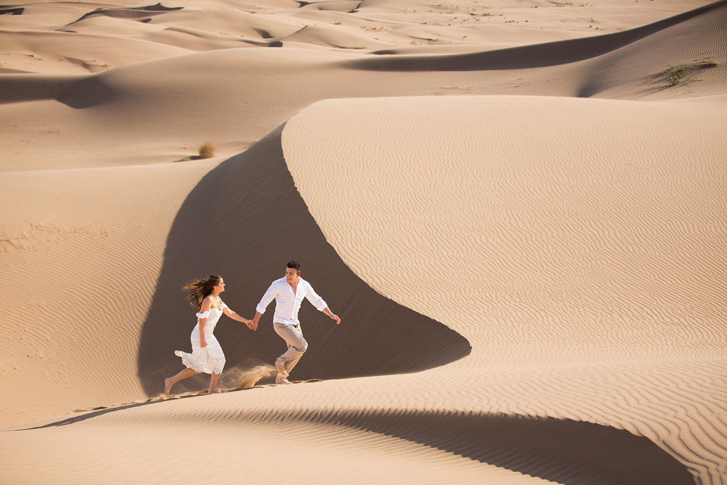 Bride and Groom Running in Epic  Glamis Sand Dunes Photo