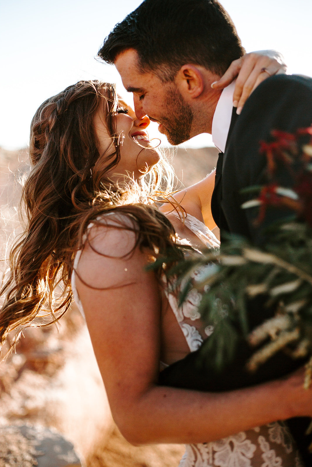 Couple with their faces together and the brides arm around the grooms neck during their Arizona Elopement