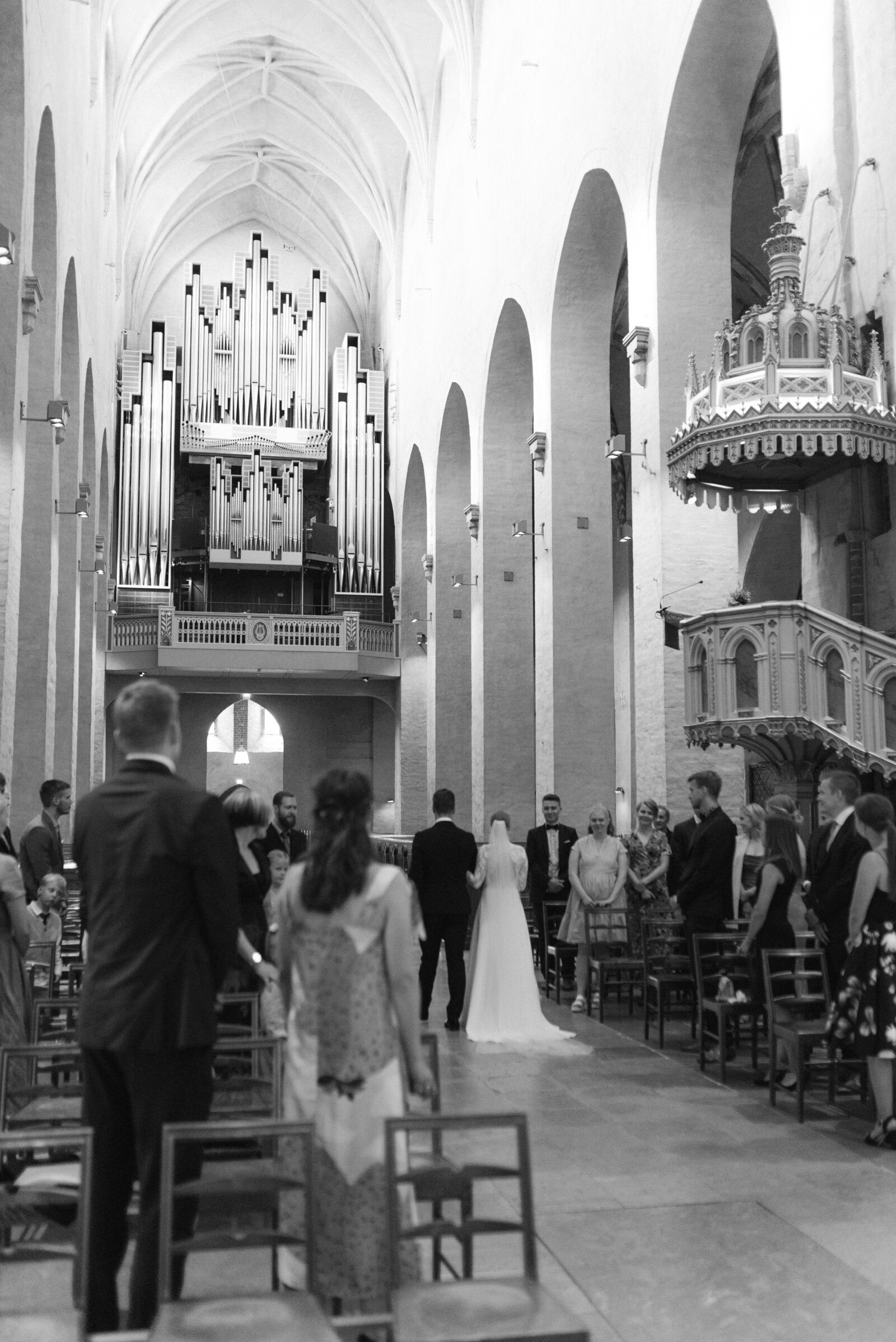 Image of wedding couple walking down the aisle  in Turku cathedral during wedding ceremony captured by wedding photographer Hannika Gabriesson.