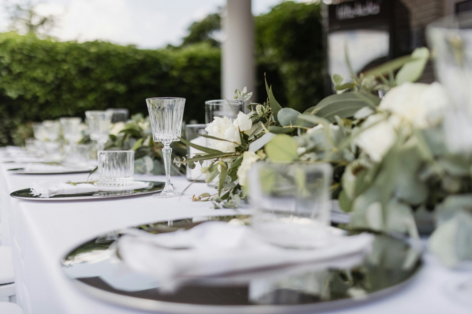 Wedding reception table with dinnerwares, glasses and floral details