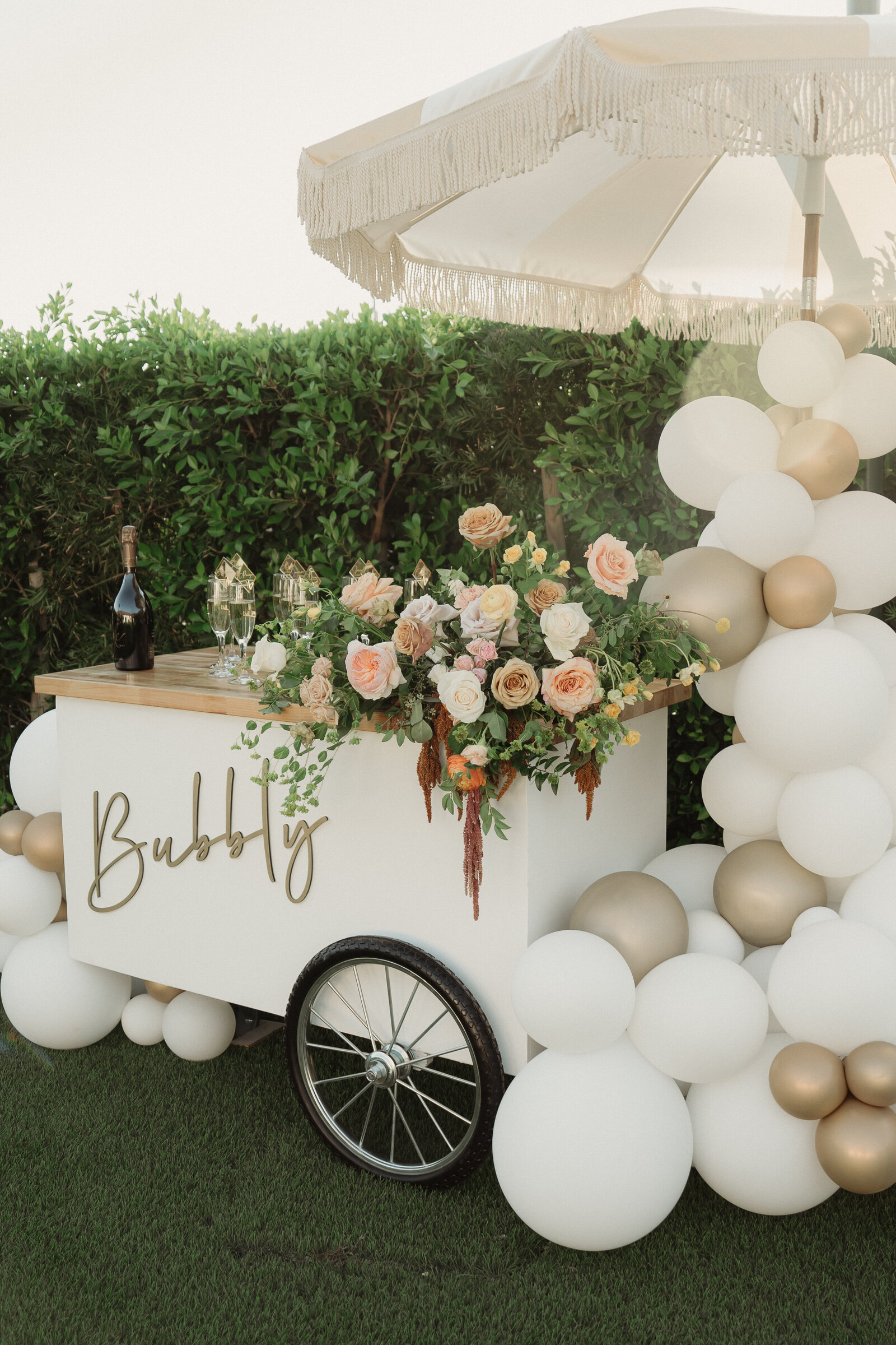 Flowers help this small champagne cart stand out at a wedding.