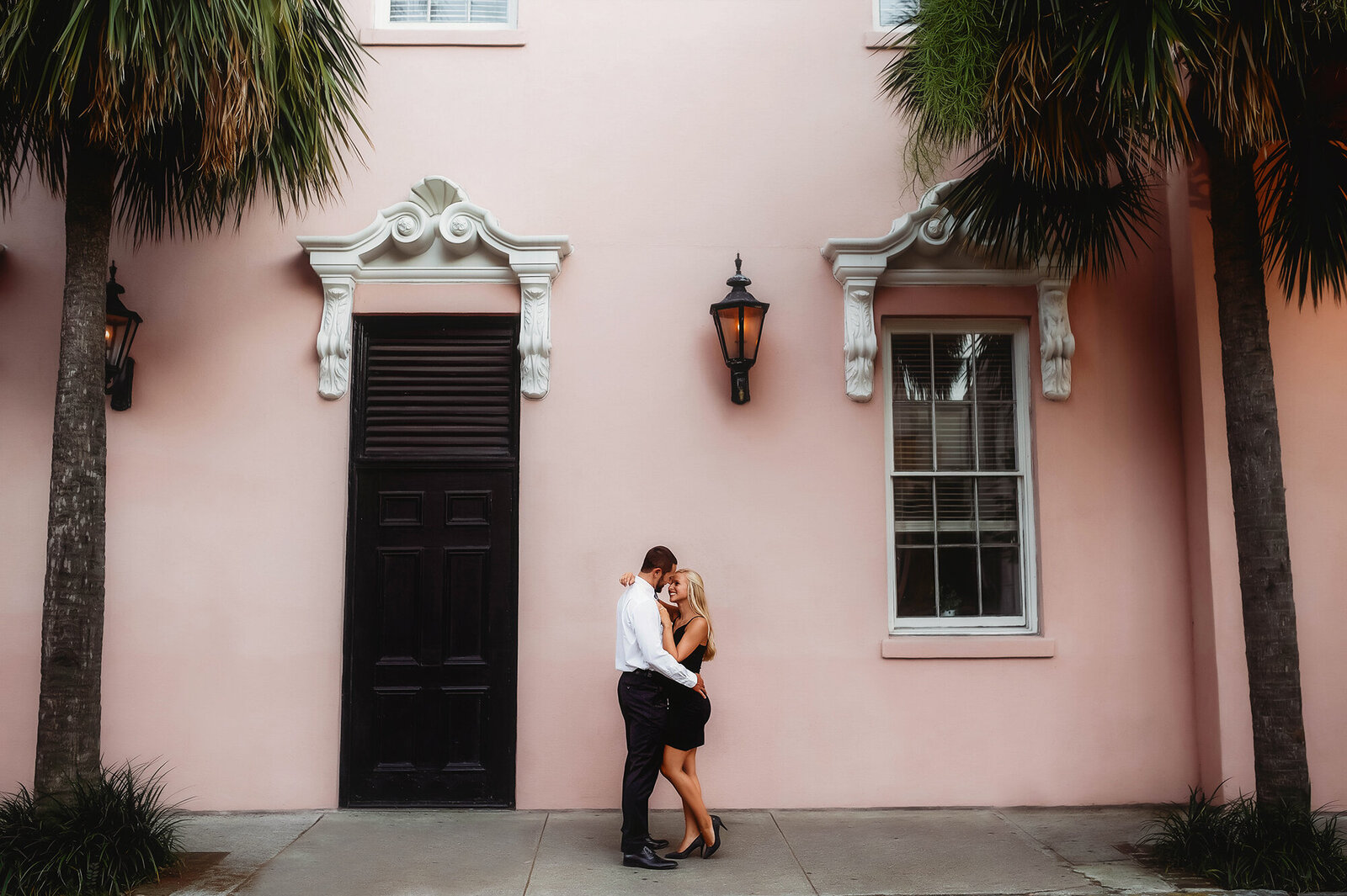 Couple kisses on as street corner, posing for Engagement Photos in Charleston, SC.