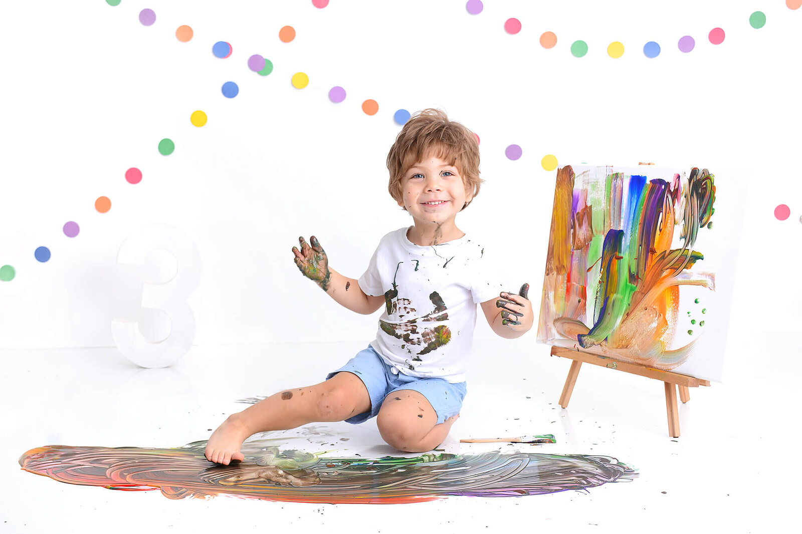 boy smiles at the camera at his 3rd birthday paint photoshoot in houston
