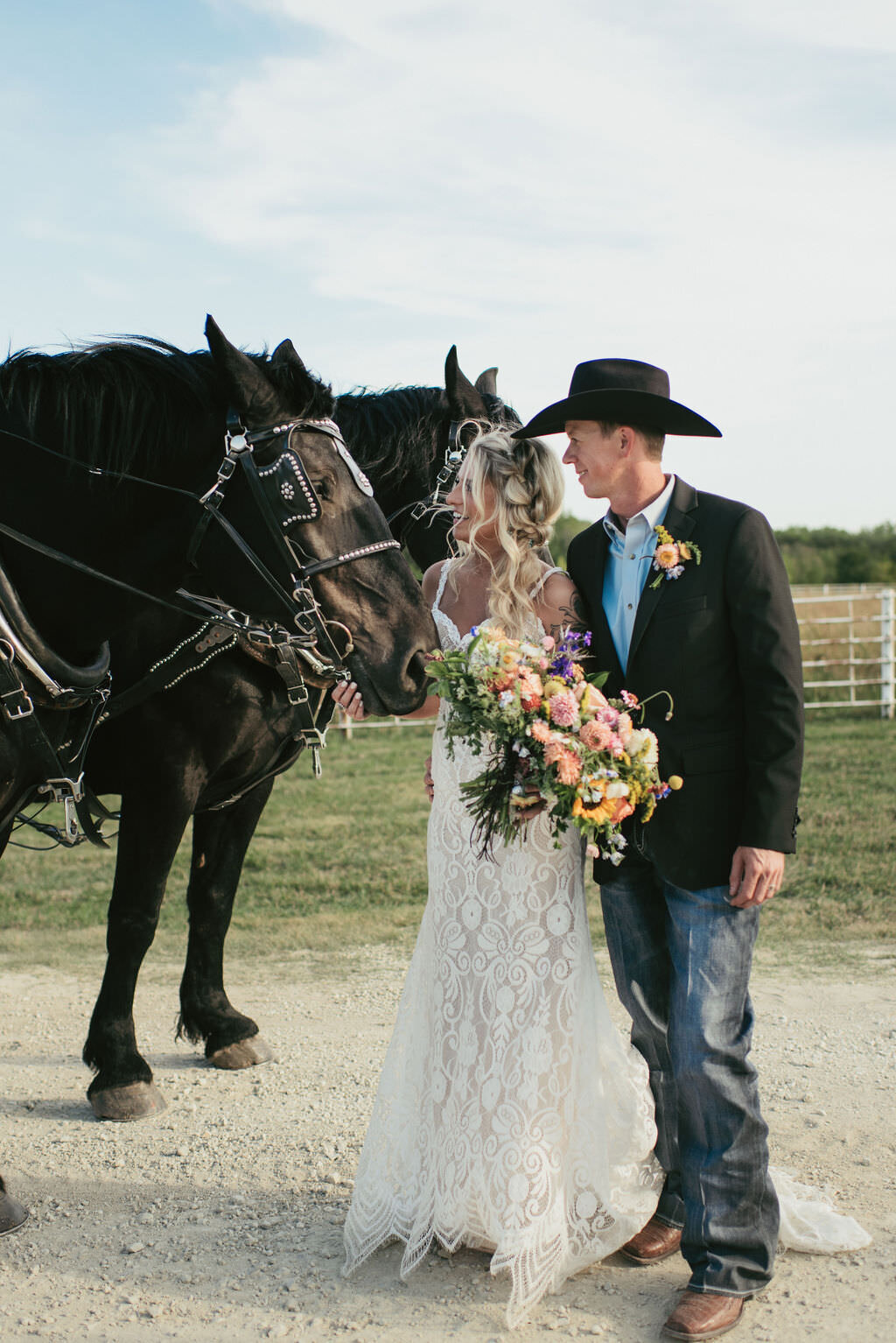 Bride and Groom Petting a horse during country wedding