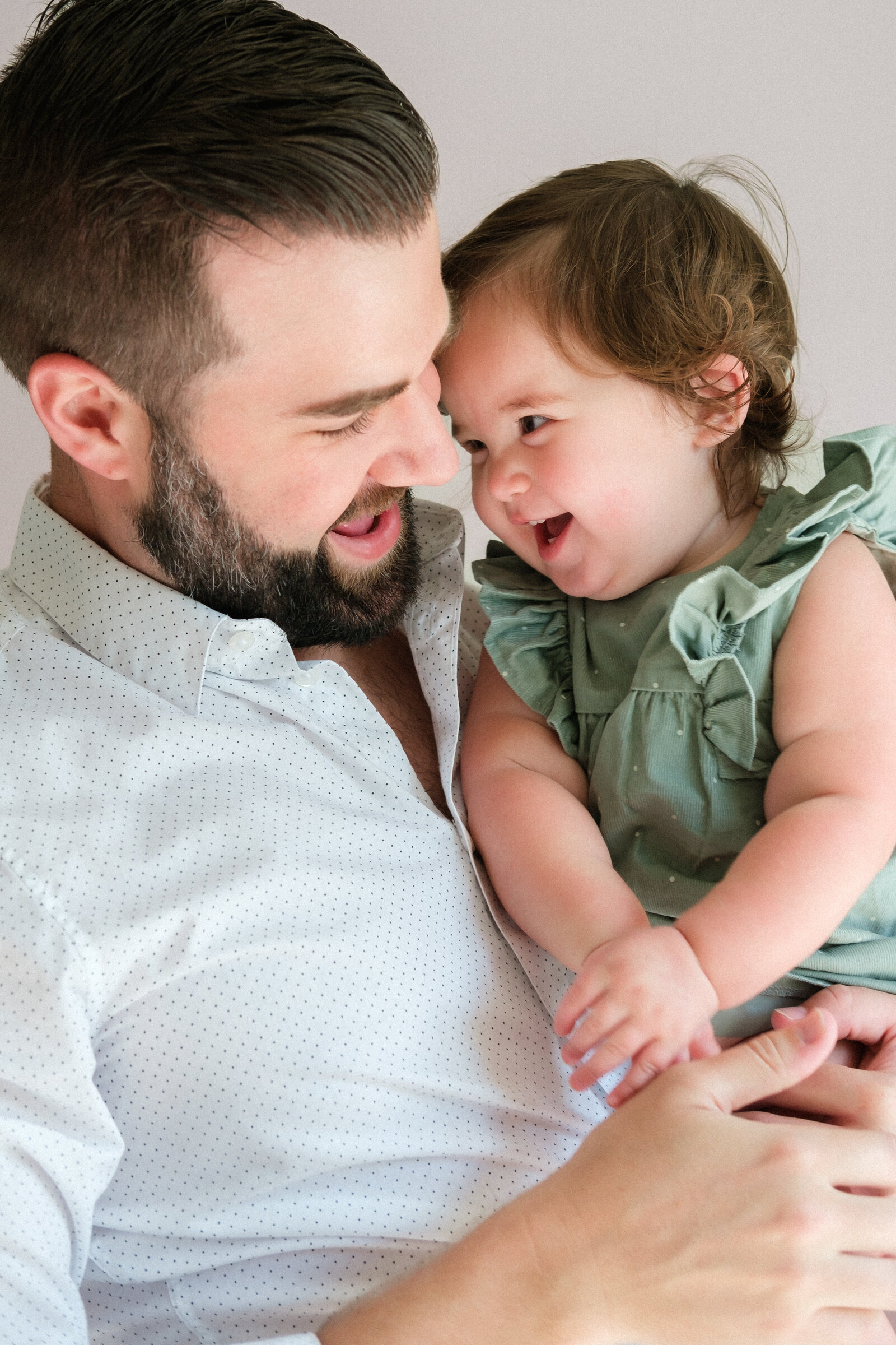 A dad laughs with his young daughter in her nursery in Odessa, FL