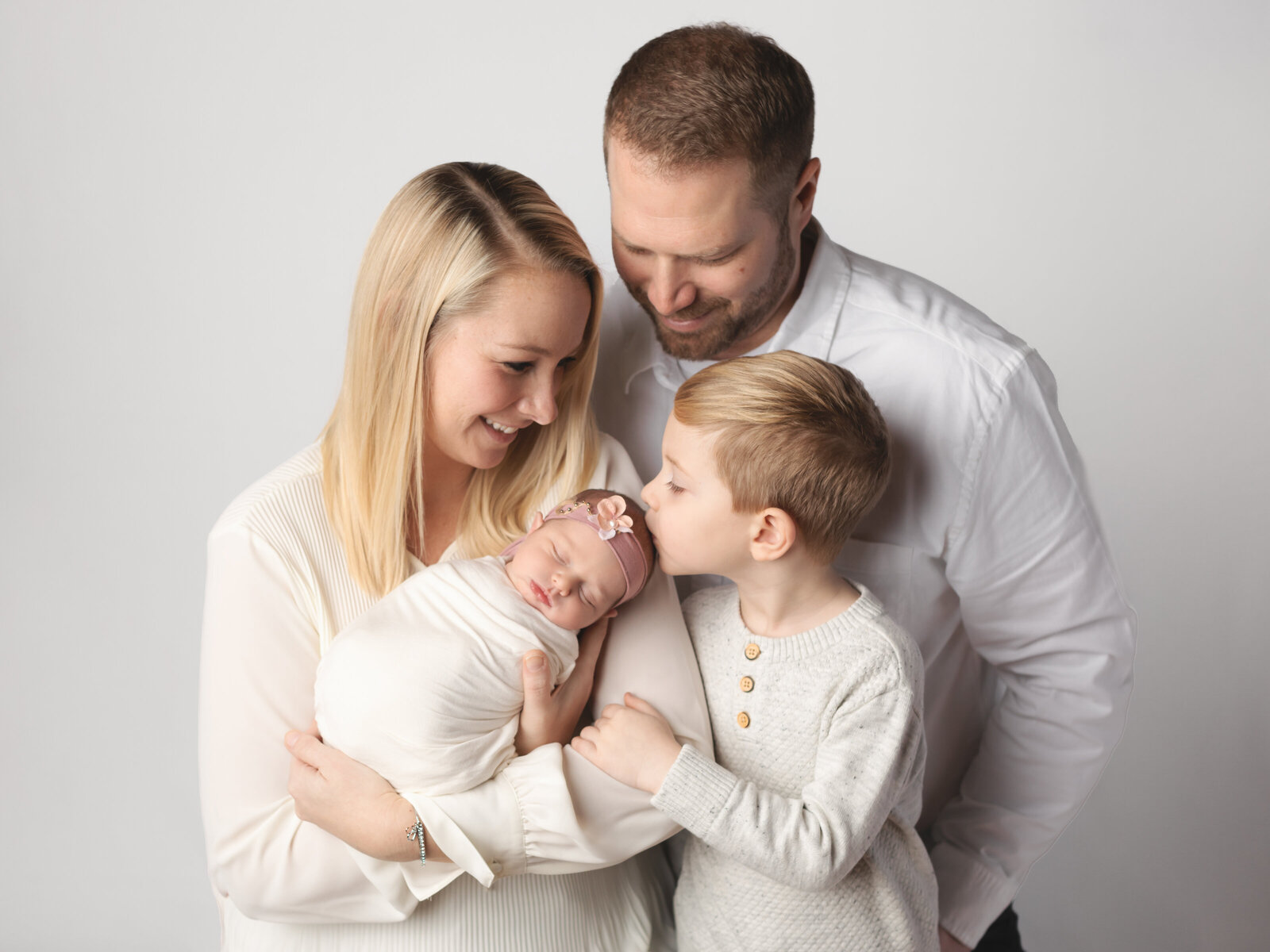 parents with son holding newborn baby girl for studio portraits cleveland newborn photographer
