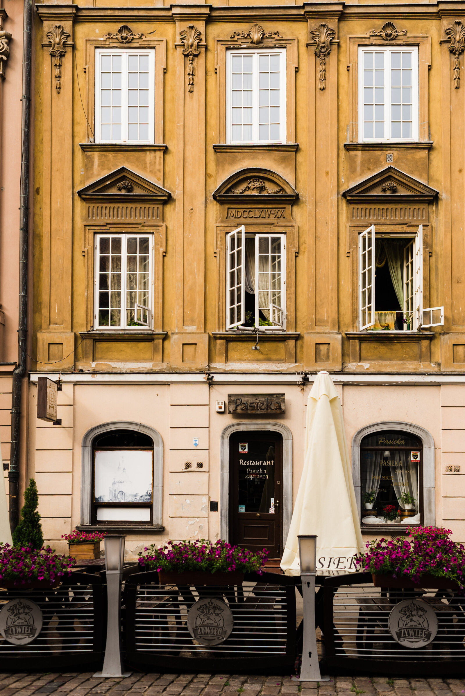 Yellow building with white trim windows in Warsaw