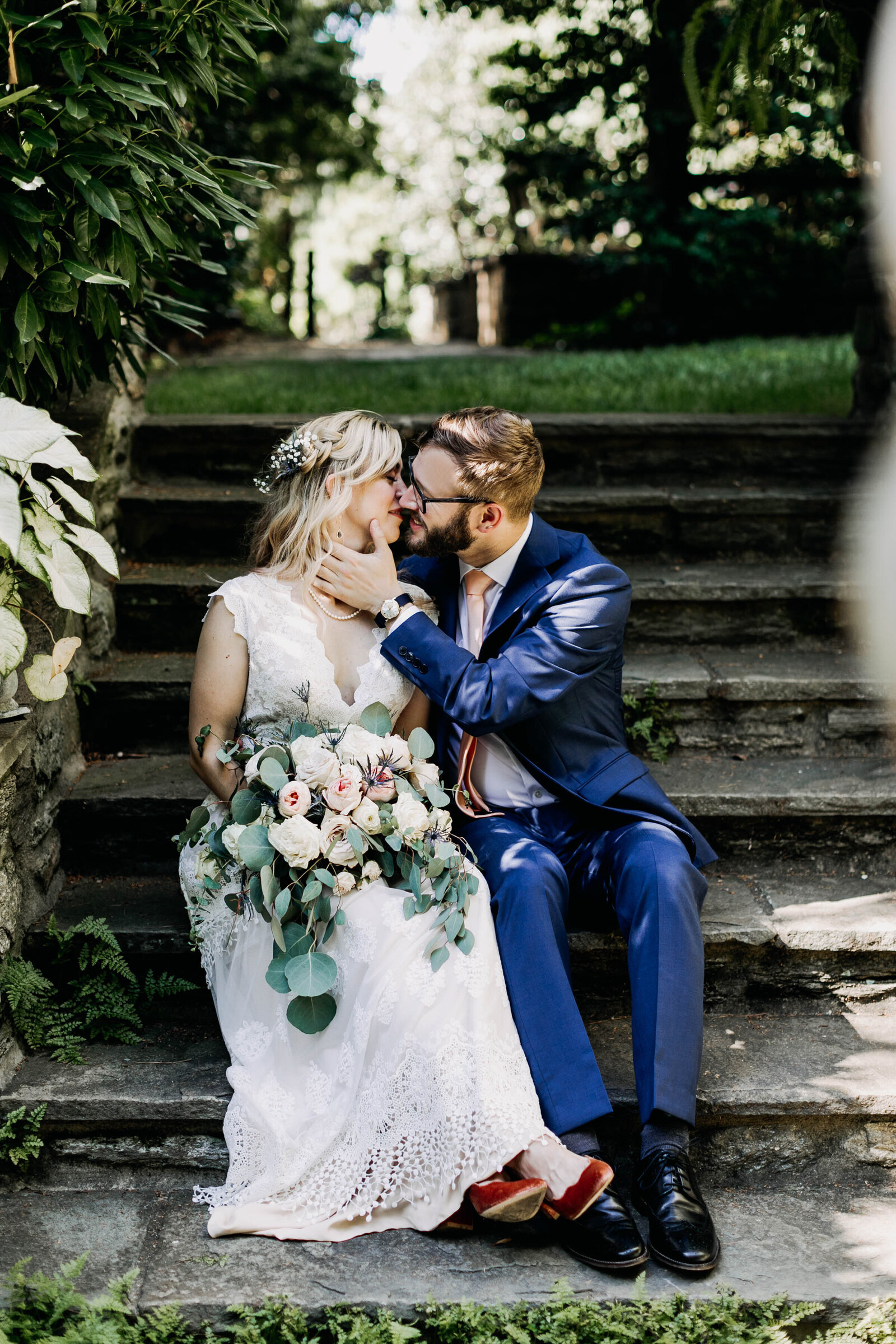 groom kissing bride on garden steps