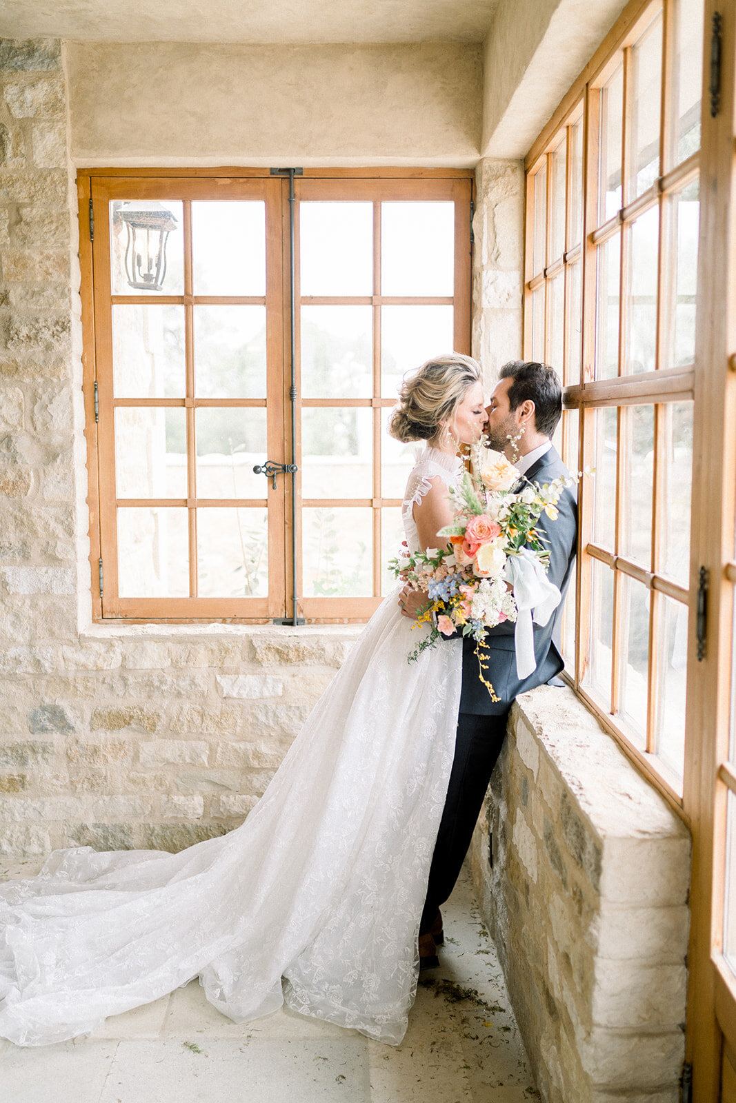 Couple kissing in the window at their Sunstone Winery wedding in Santa Ynez, CA