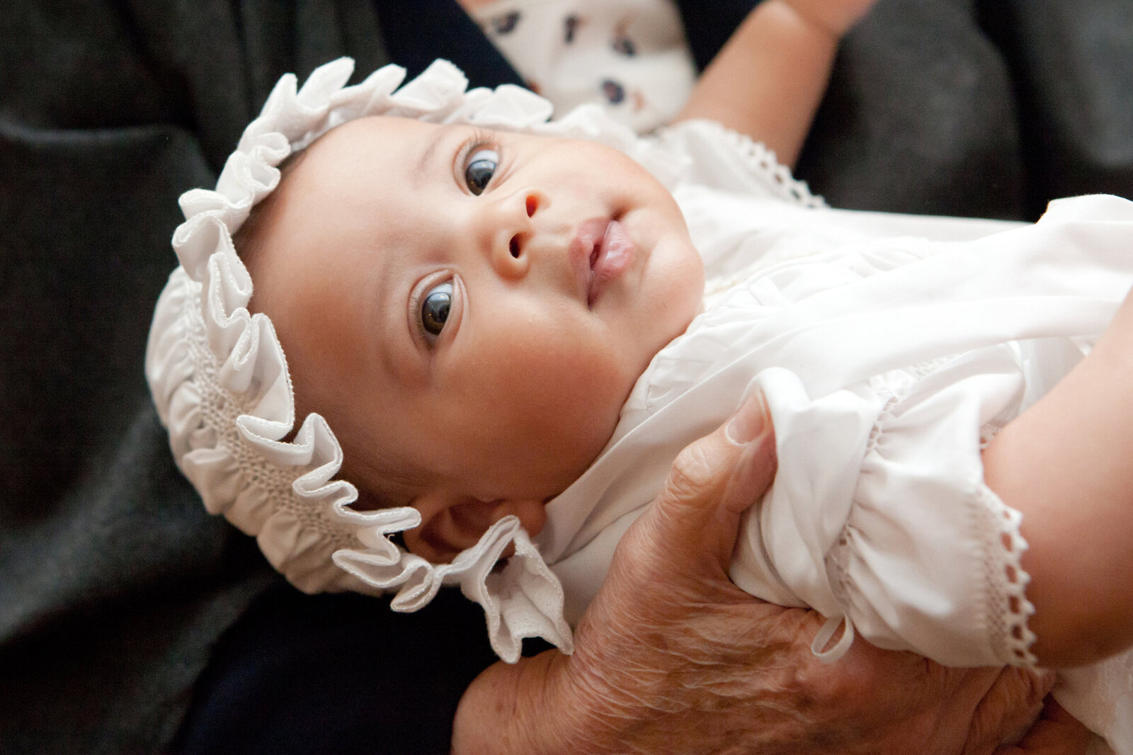 baby girl in baptismal gown and hat smiles baptism Rockland County New City baptism photographer Milestone Images