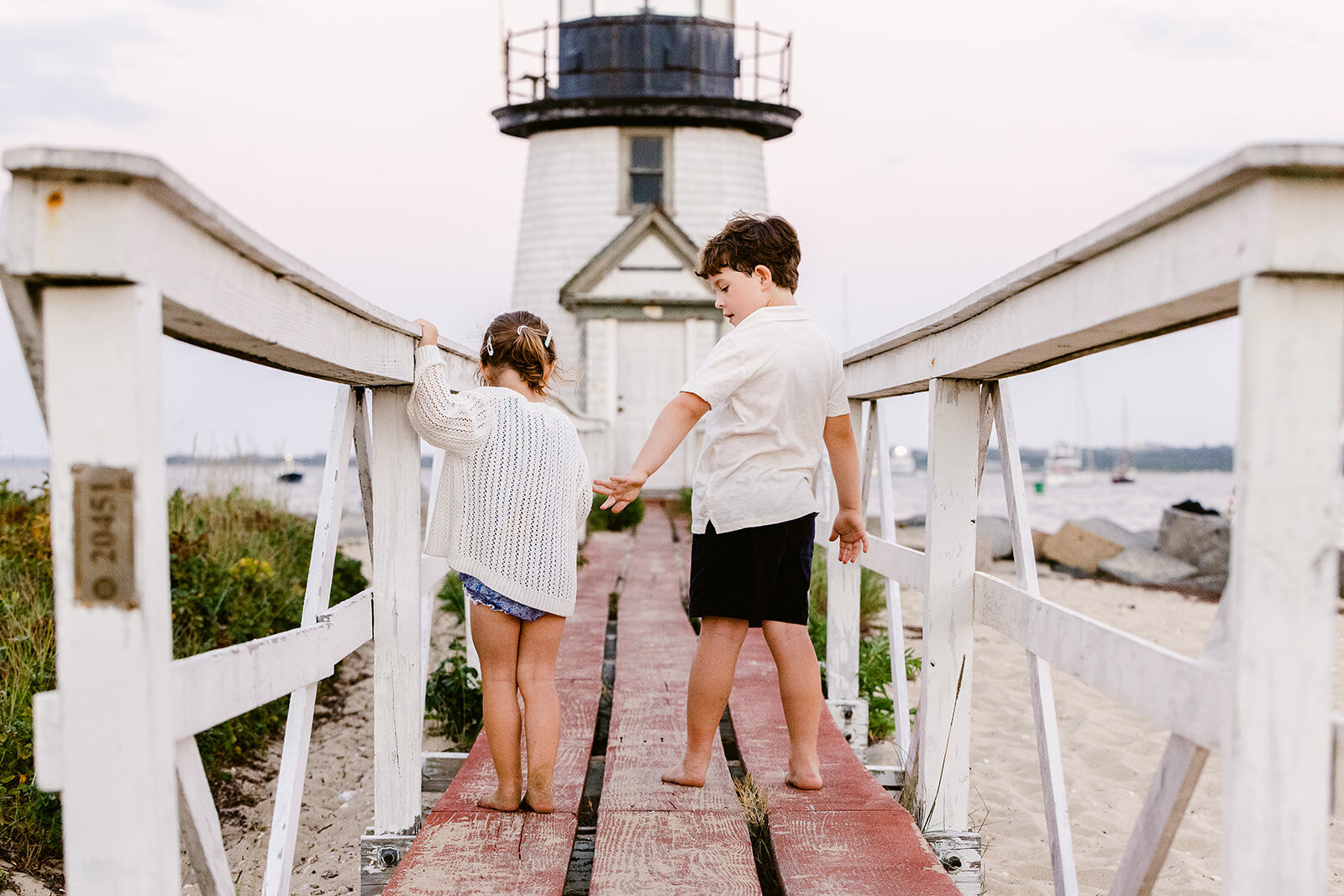 siblings holding hands at brant point lighthouse
