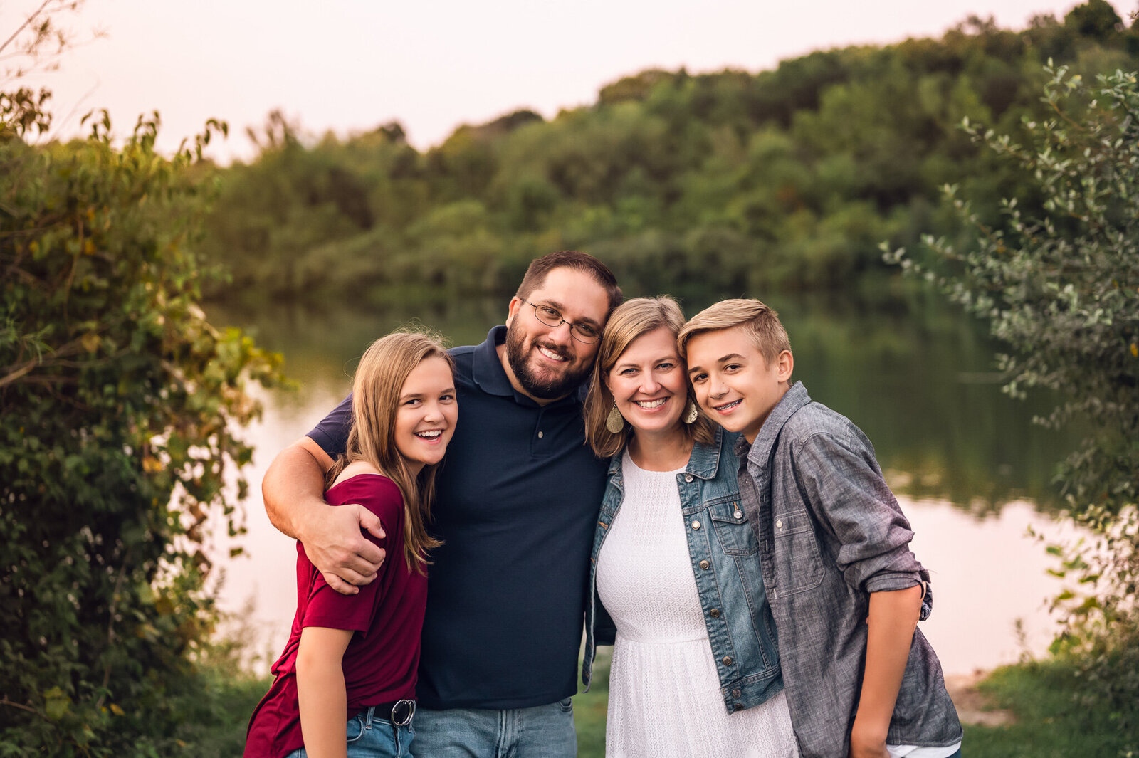 Family smiling near a lake