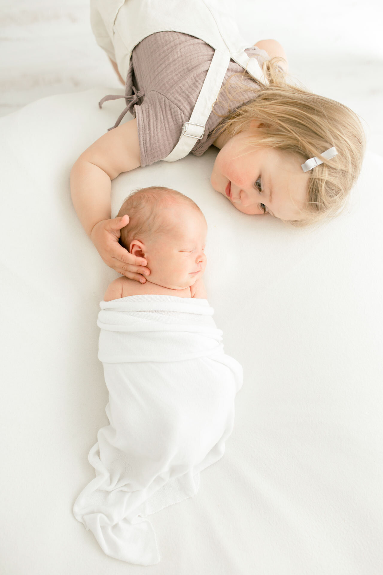 Babyfotografie: Neugeborenes mit Schwester (Kleinkind) bei einem Neugeborenenfotoshooting in Gütersloh bei Bielefeld.
