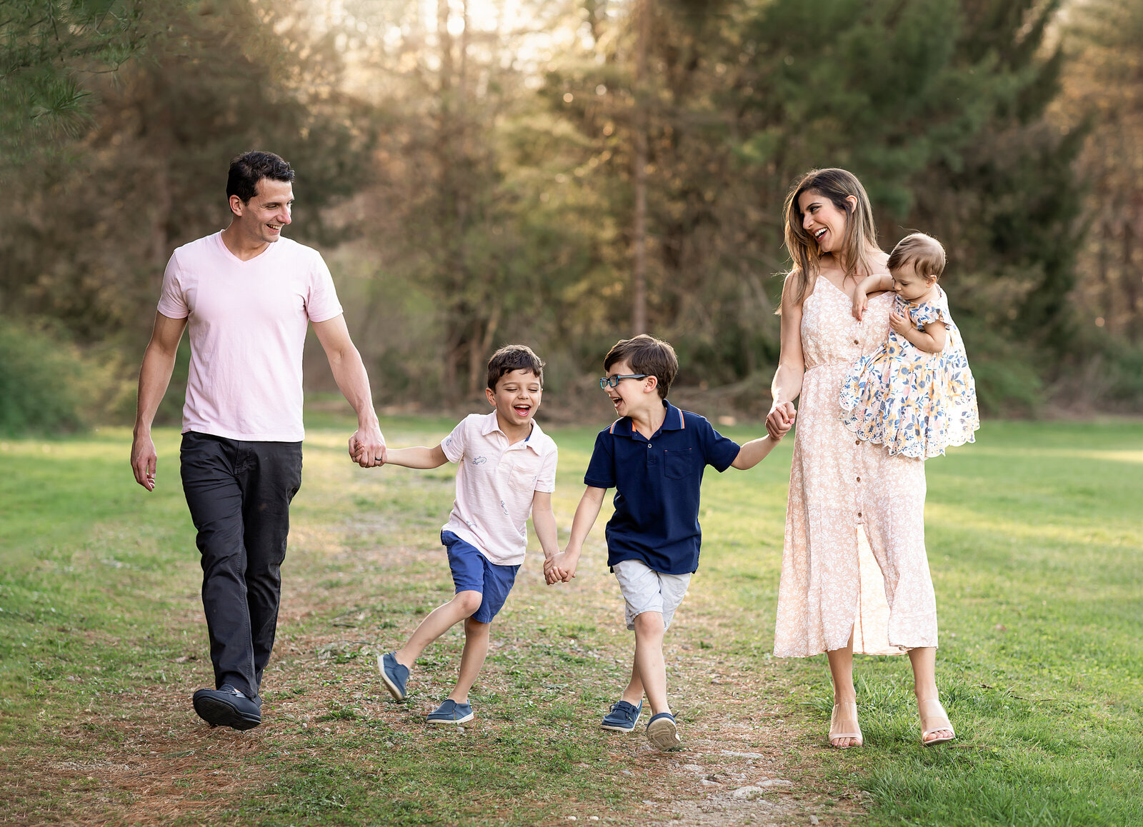 mom, dad and three children holding hands and walking for family photography