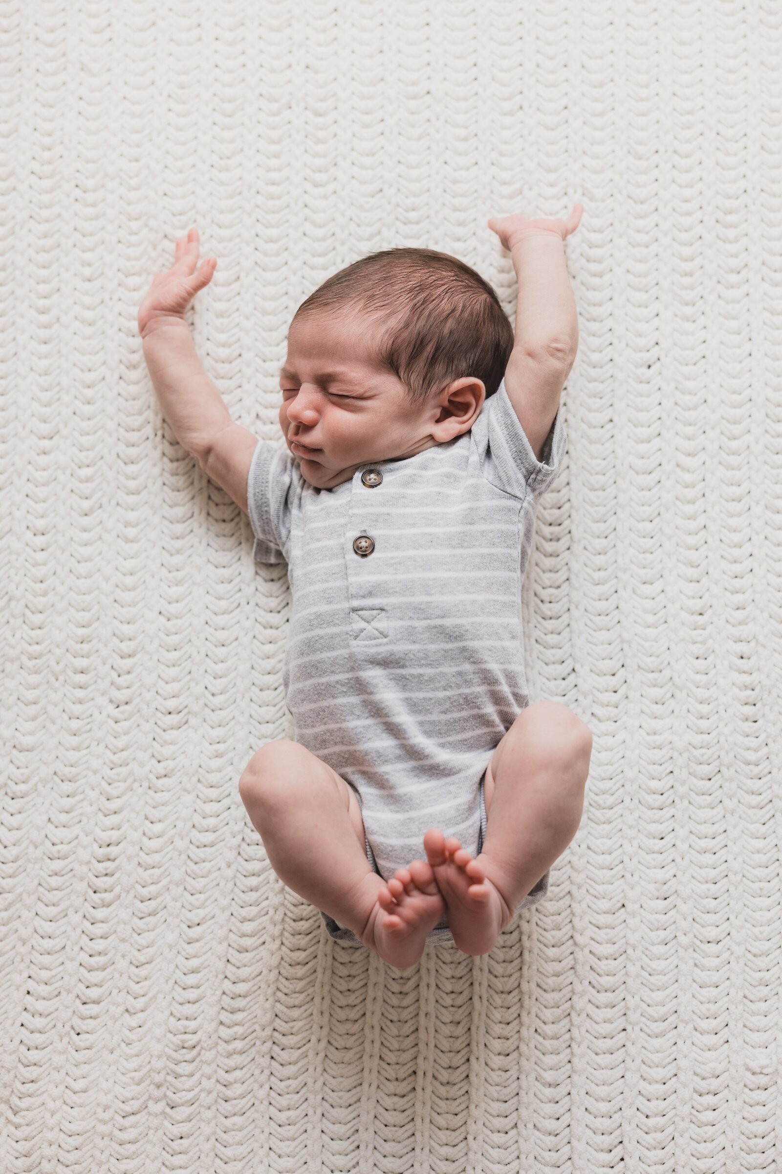 Newborn stretching during photography session in Pensacola, FL by Jennifer Beal Photography