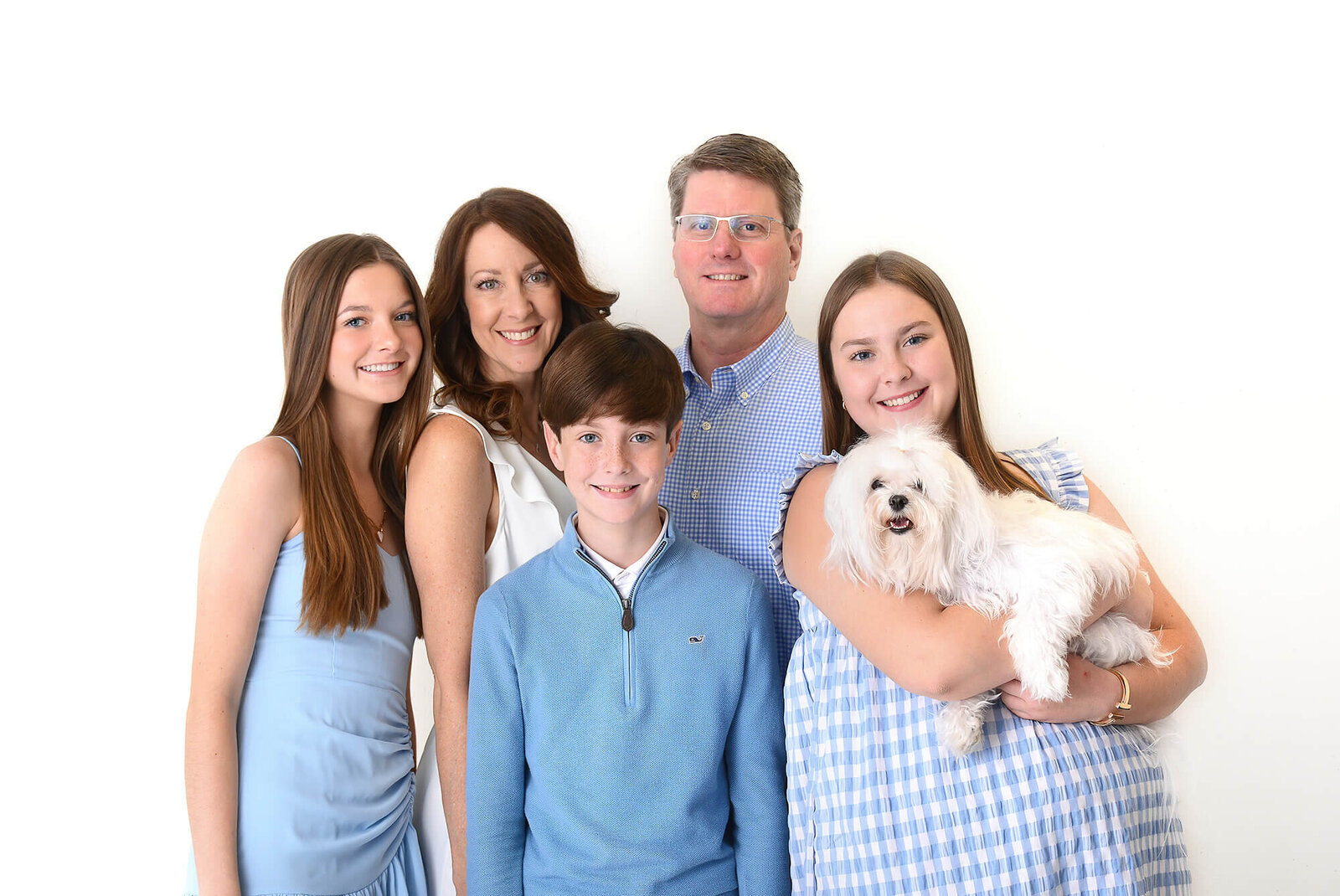 family and their dog smile at their family photoshoot