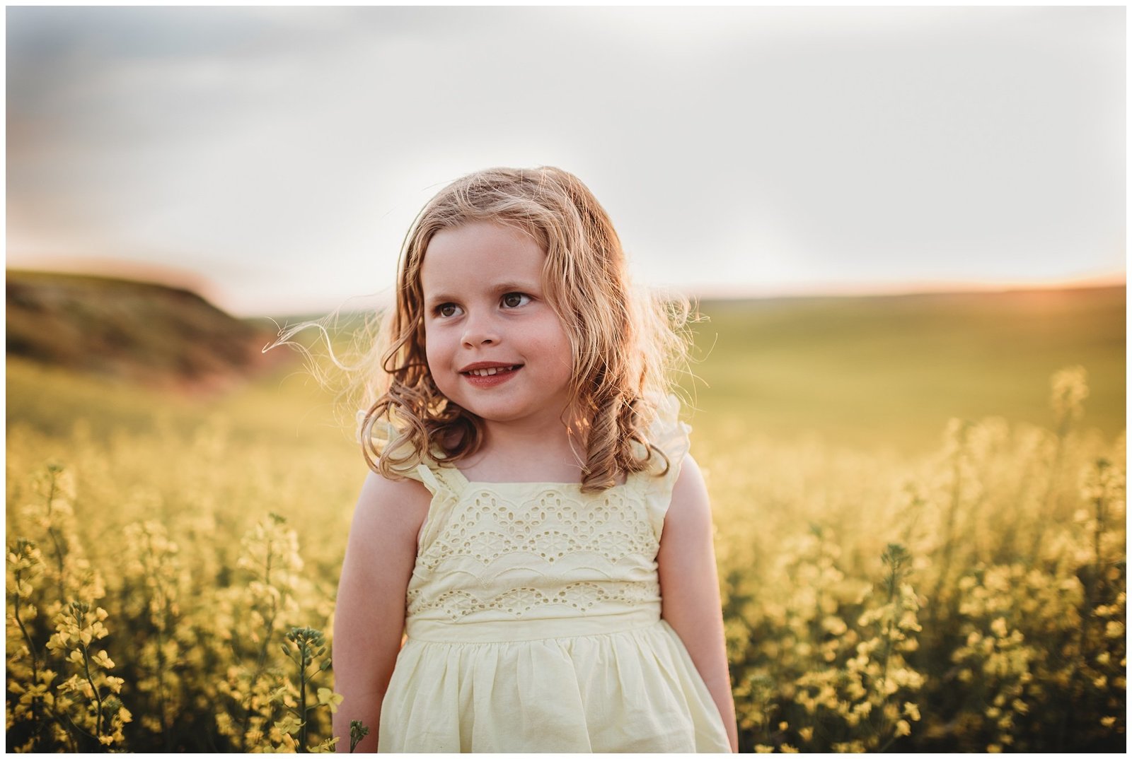 blonde curly hair girl in yellow dress in field of yellow flowers at sunset Emily Ann Photography Seattle Family Photographer