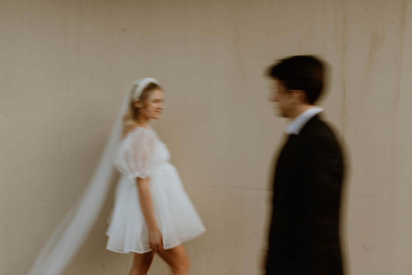 An elopement couple walking past each other in motion blur