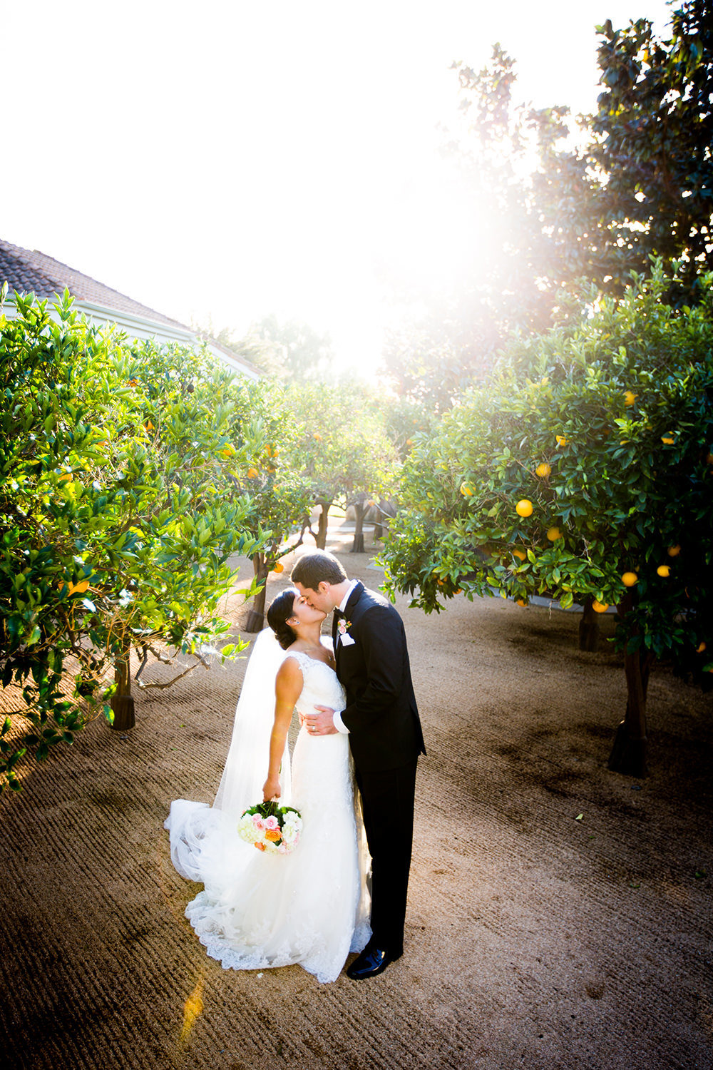 bride and groom at the crosby club beautiful light on bridge with orange trees