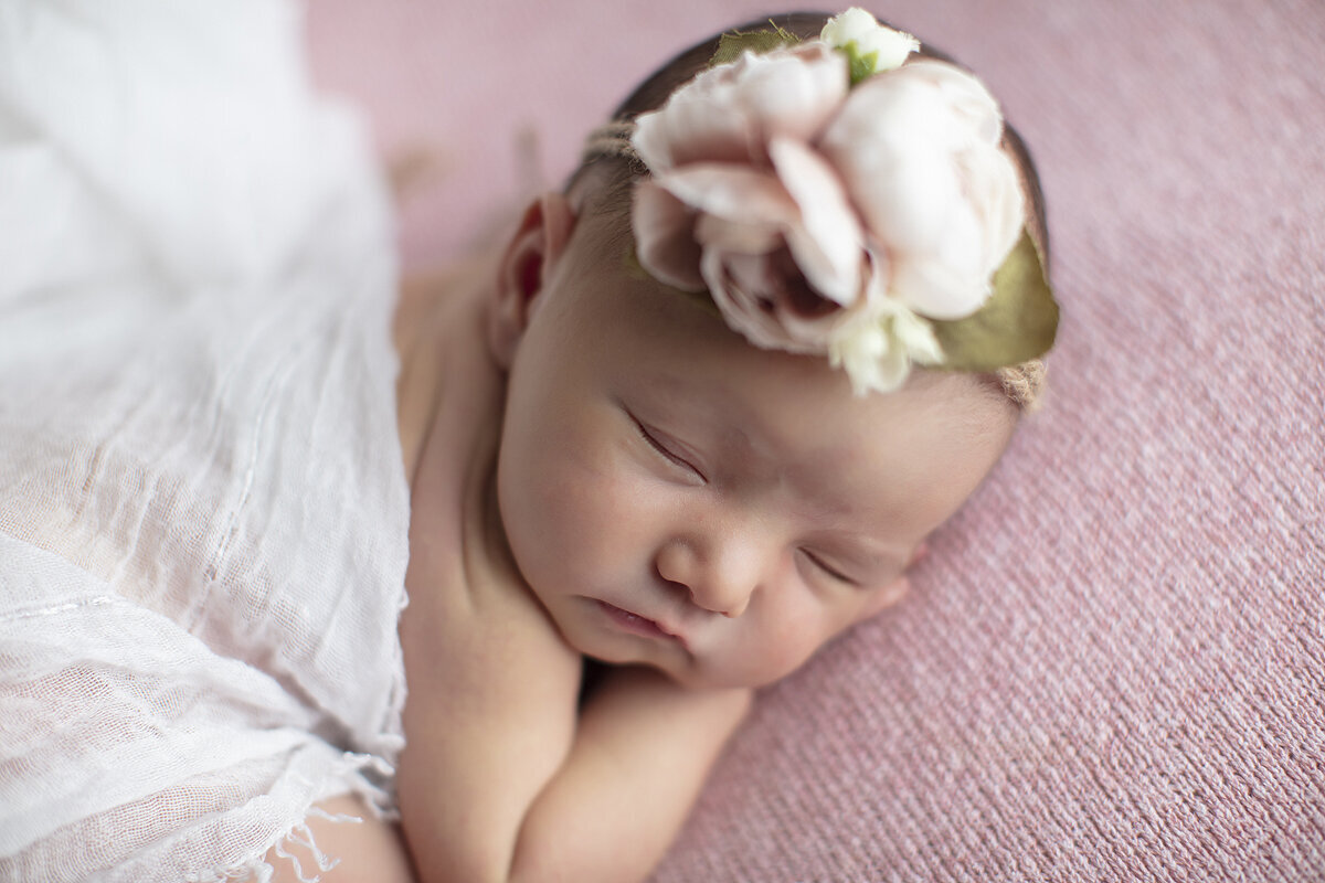 Dallas newborn close up on pink fabric.