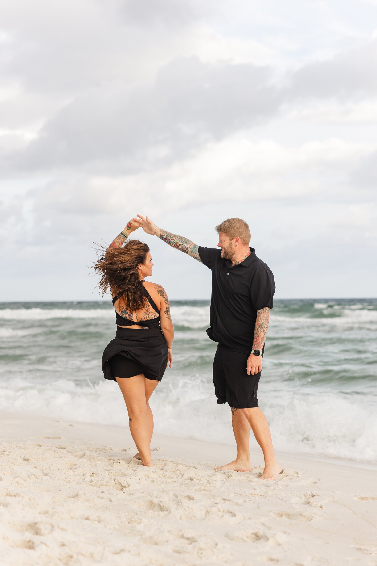 Couple dancing on Pensacola Beach at sunset during  photo session by Jennifer Beal Photography