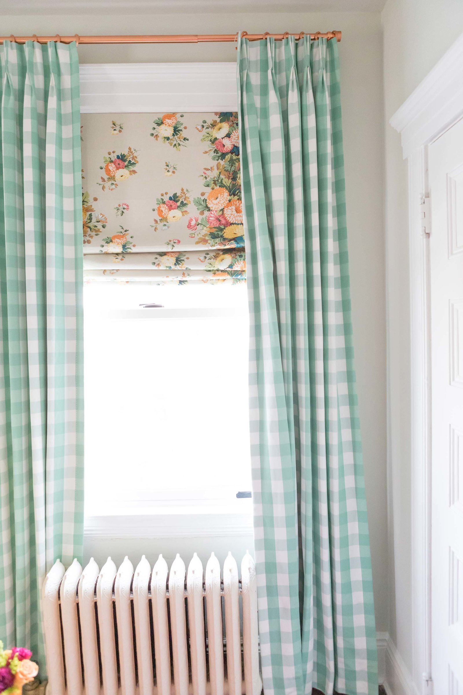 Mint gingham and floral curtains in a nursery.