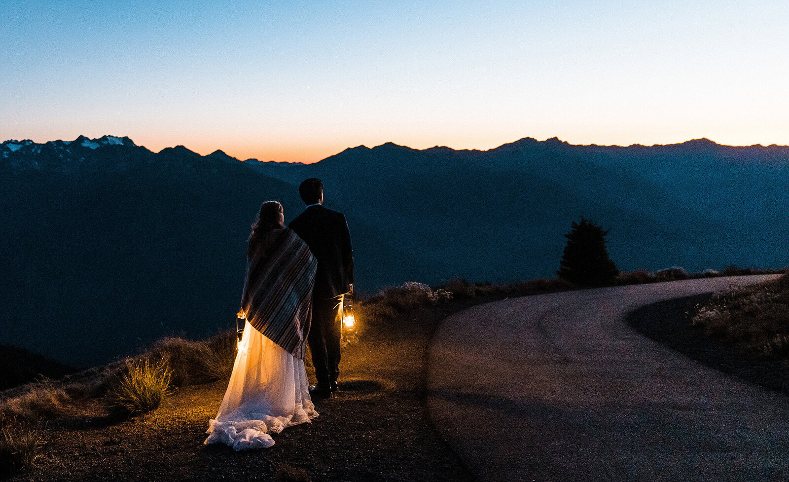 A bride and groom walk with lanterns after sunset at Hurricane Ridge photographed by Amy Galbraith