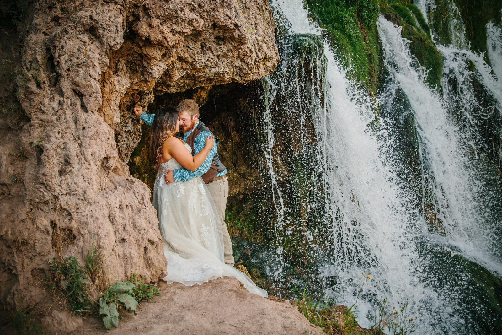 Jackson Hole photographers capture waterfall bridals with couple kissing