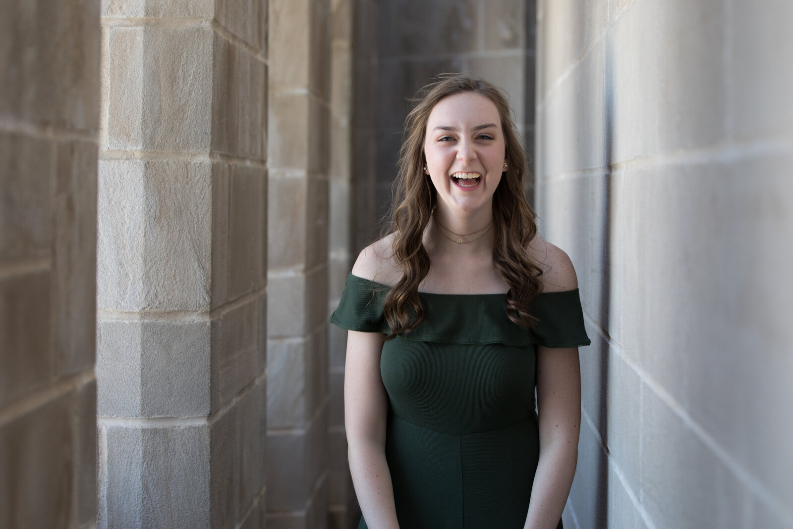 Senior laughs while posing in the Capitol during a senior photo shoot