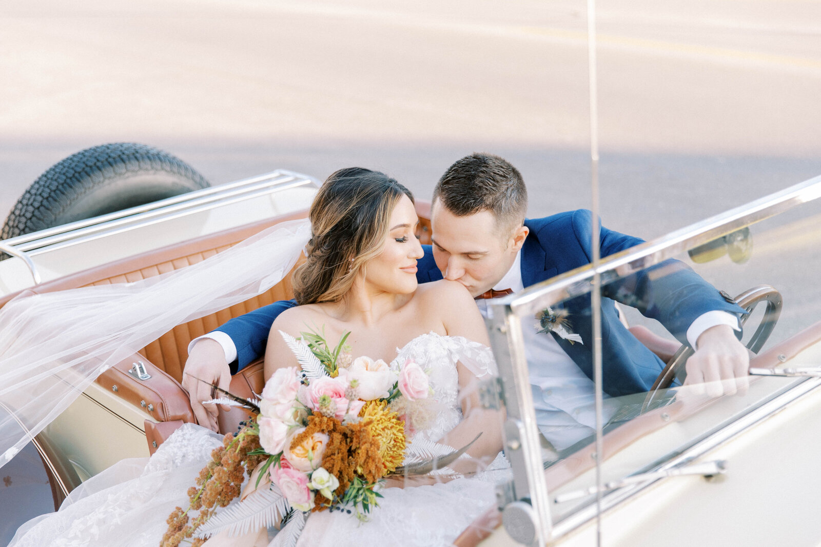 Bride and groom share soft shoulder kiss in vintage car kansas city