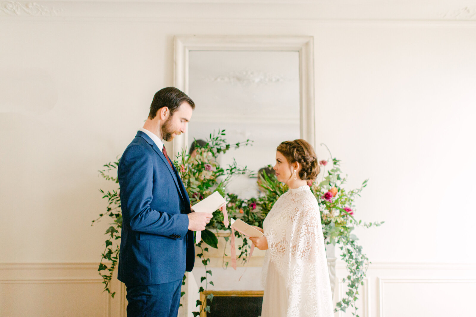 bride and groom in front of fireplace mantel in paris apartment exchanging vows