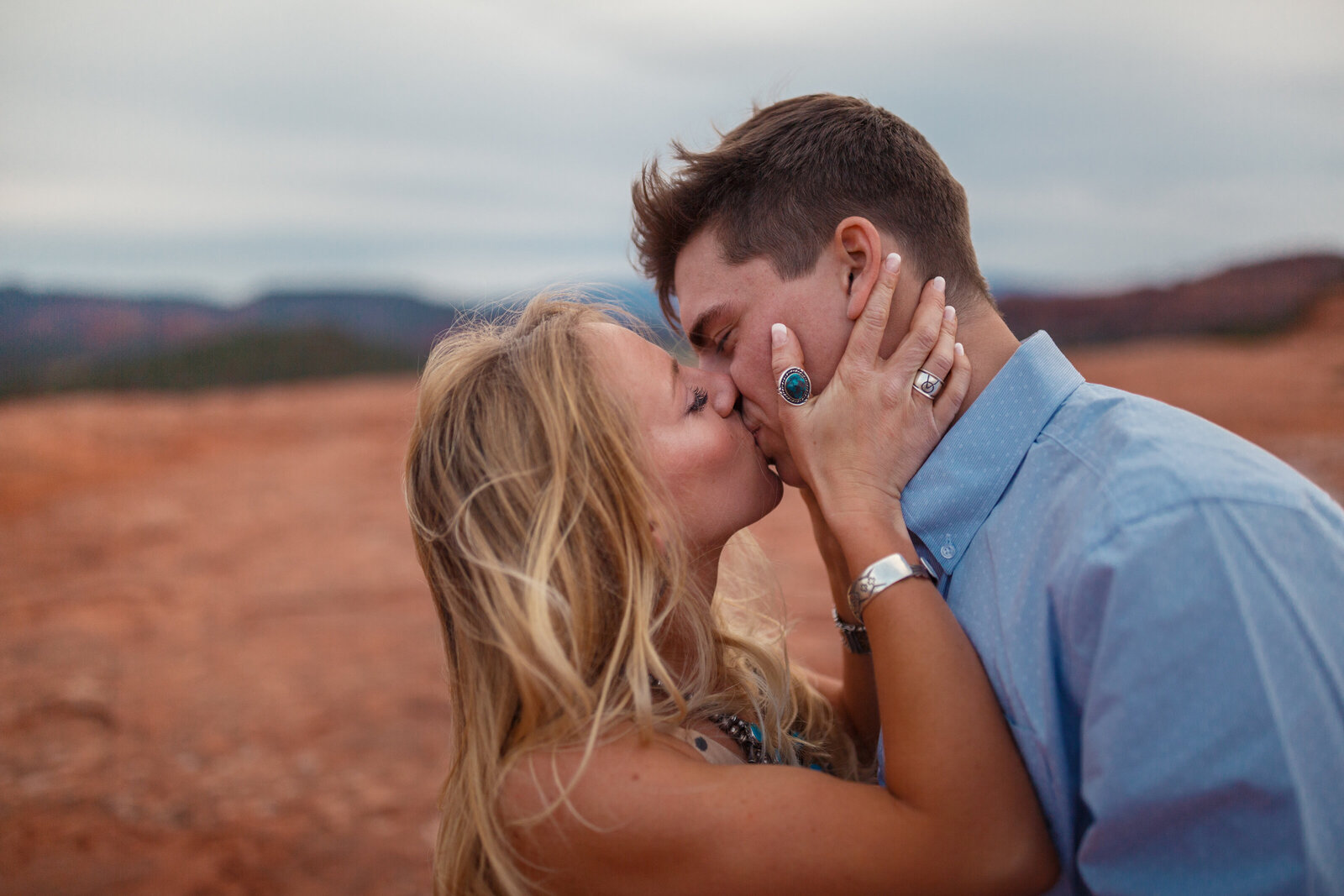 bride with turquoise rings kissing groom in sedona