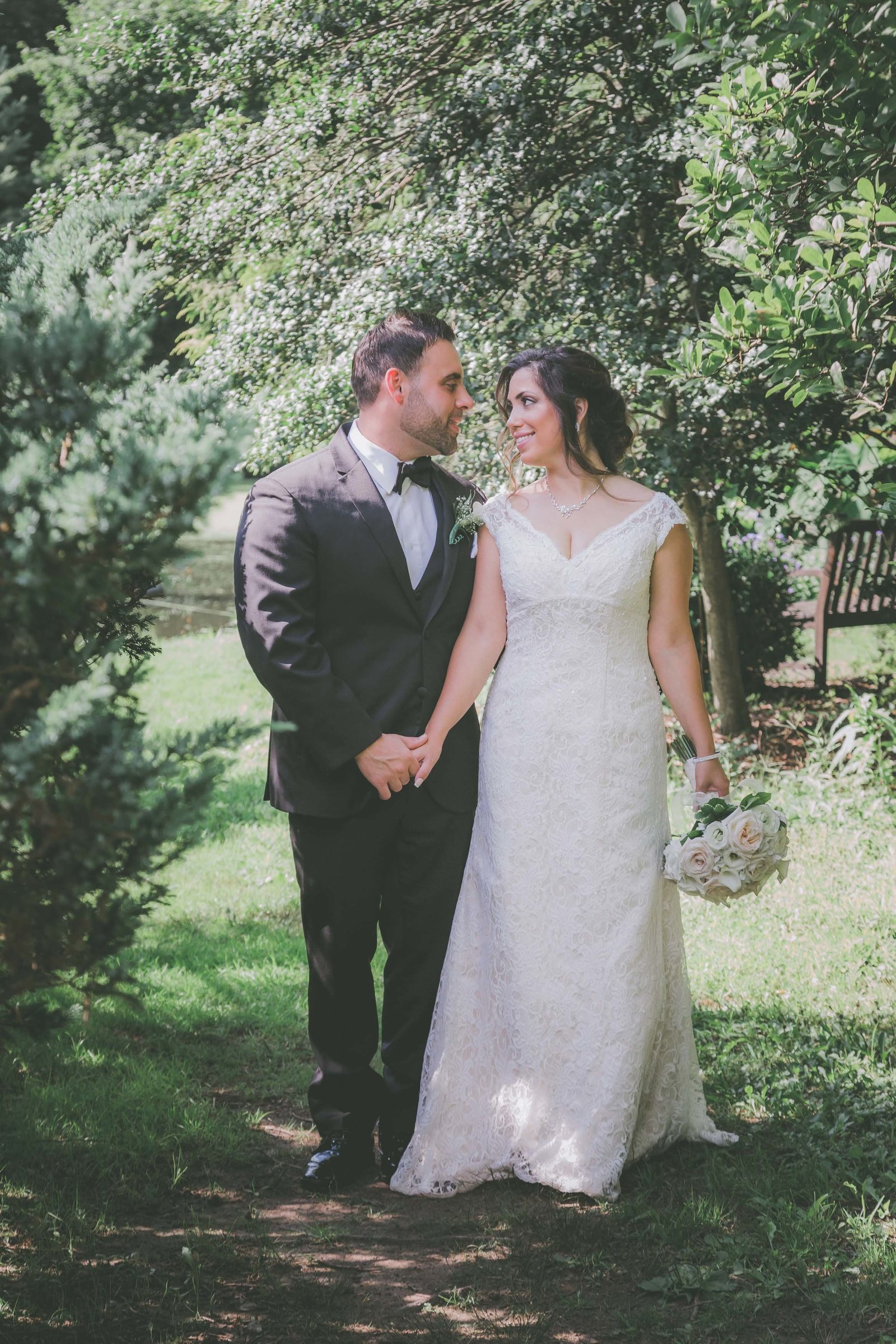 A couple hold hands and look at each other in a California garden for their elopement.