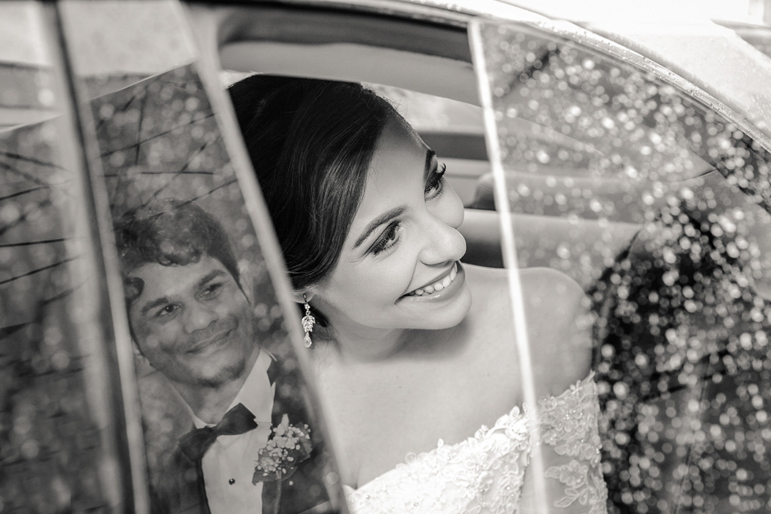 Bride in car with groom's reflection in B+W. Photo by Ross Photography, Trinidad, W.I..