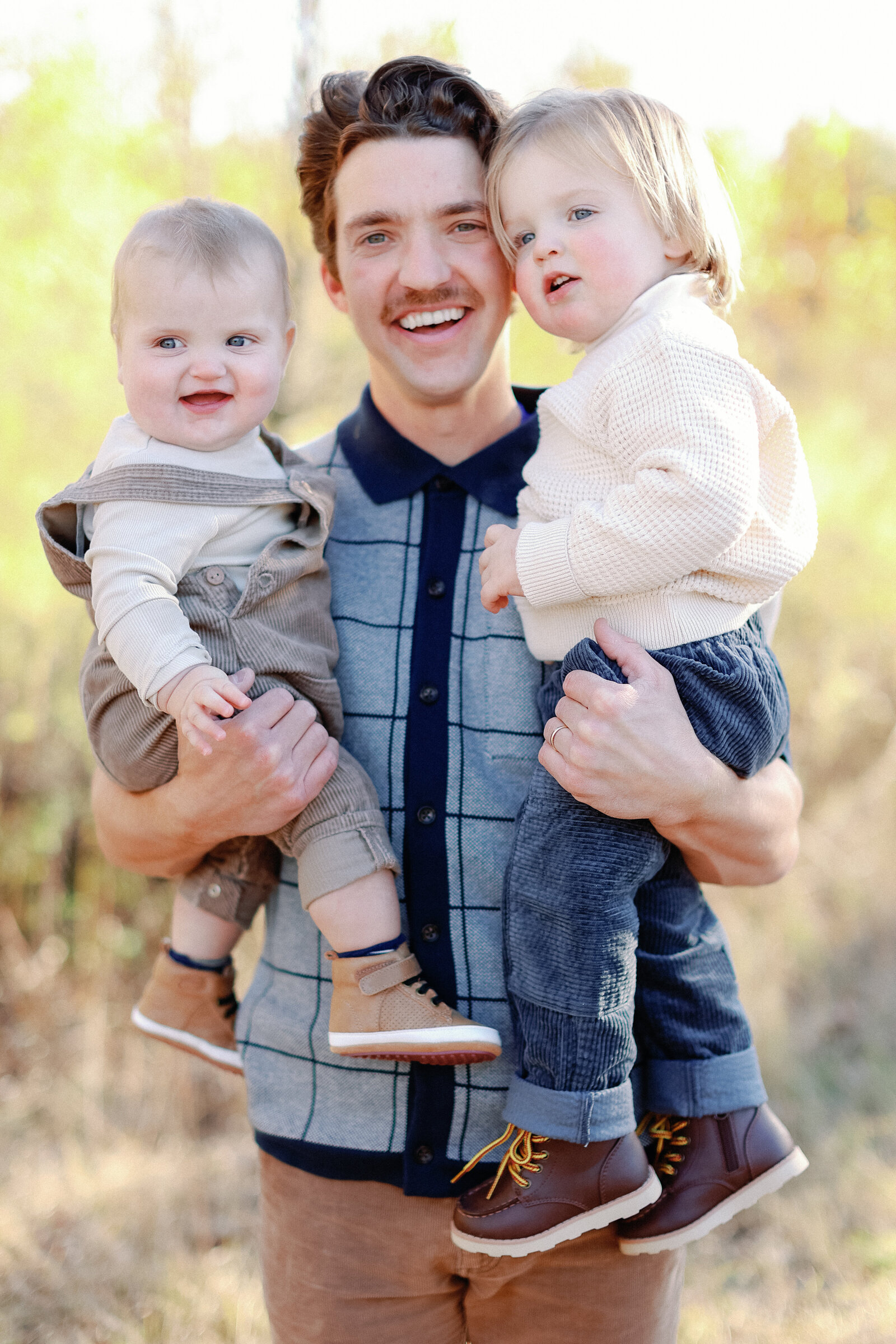 dad holding his little boys for fall family photos