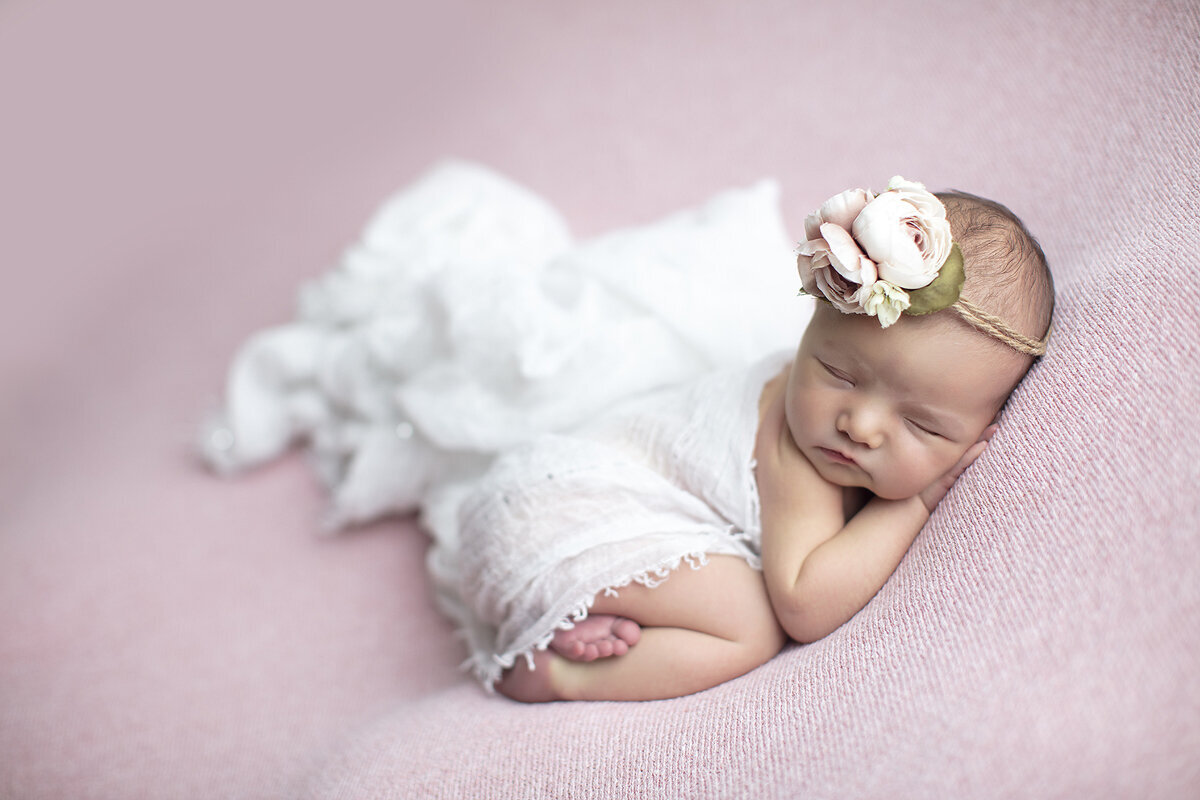Newborn girl on pink, posed by a Dallas newborn photographer.