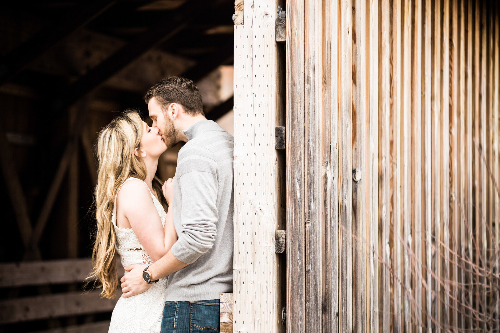 Couple kissing under a covered bridge