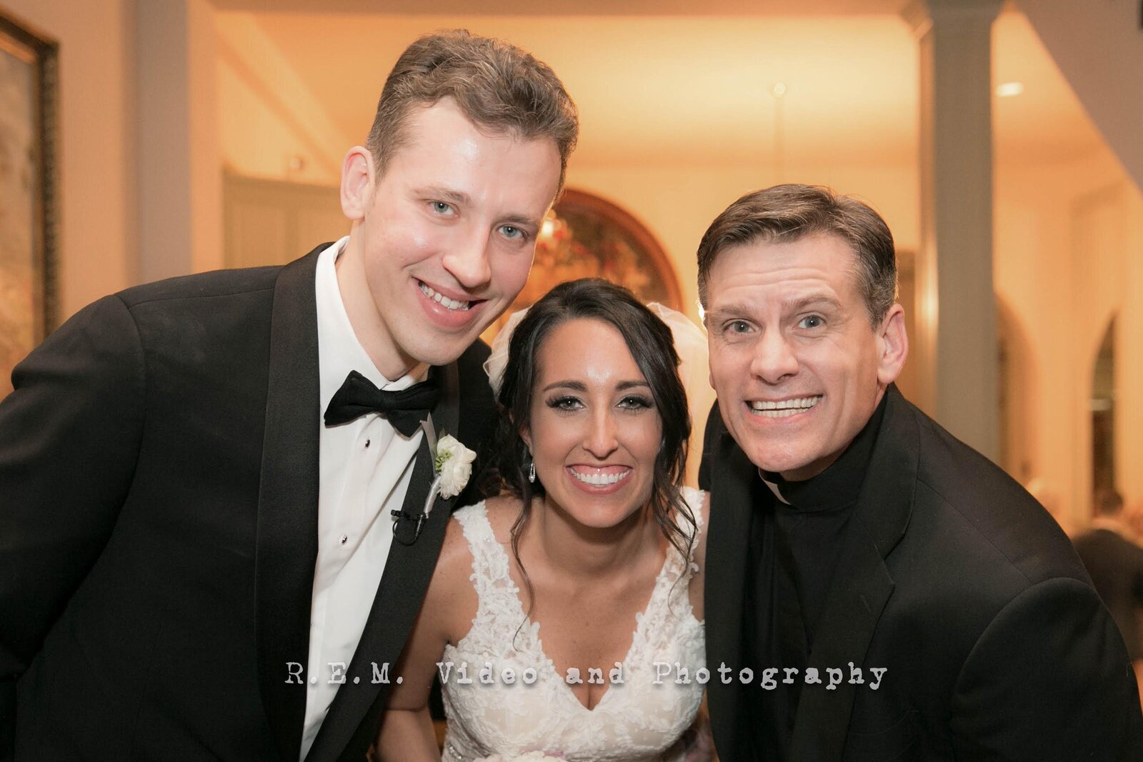 Bride, groom, and wedding officiant smile for portrait